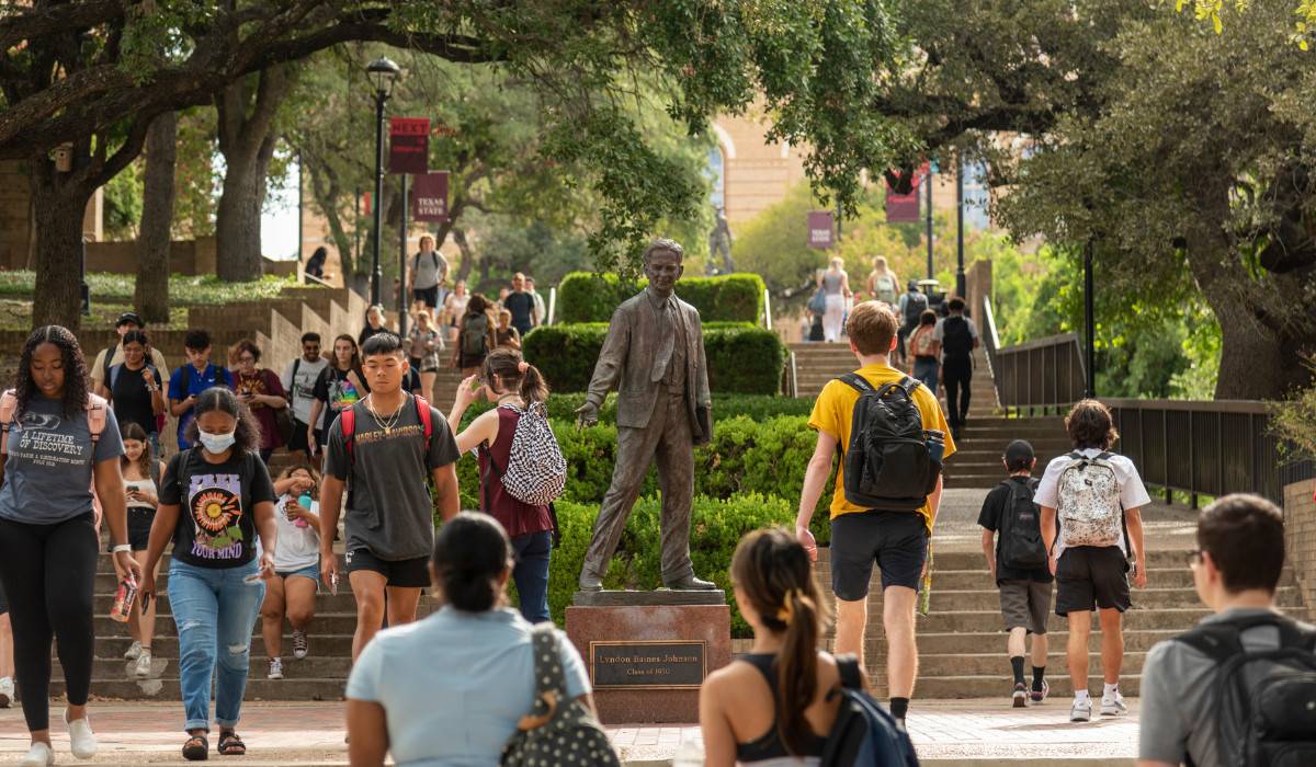 Students walking in front of LBJ Statue