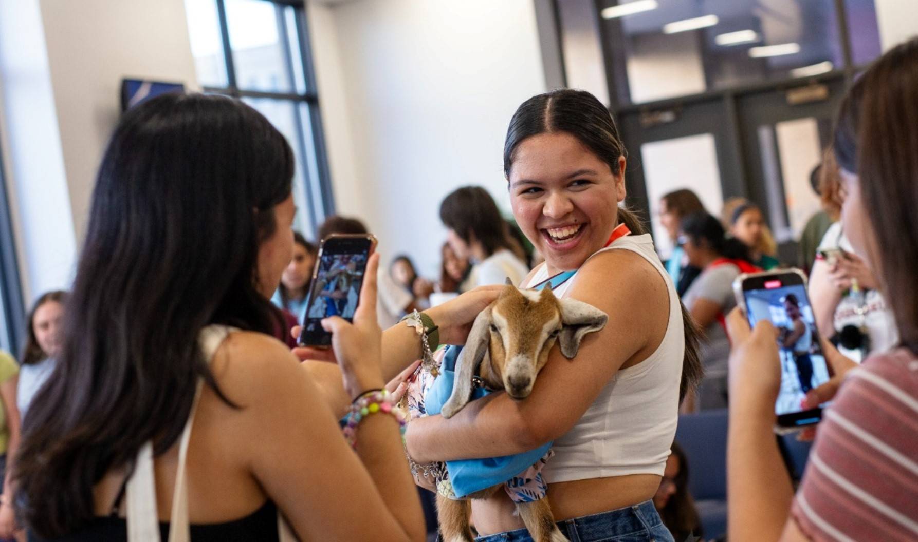 Student holding a goat