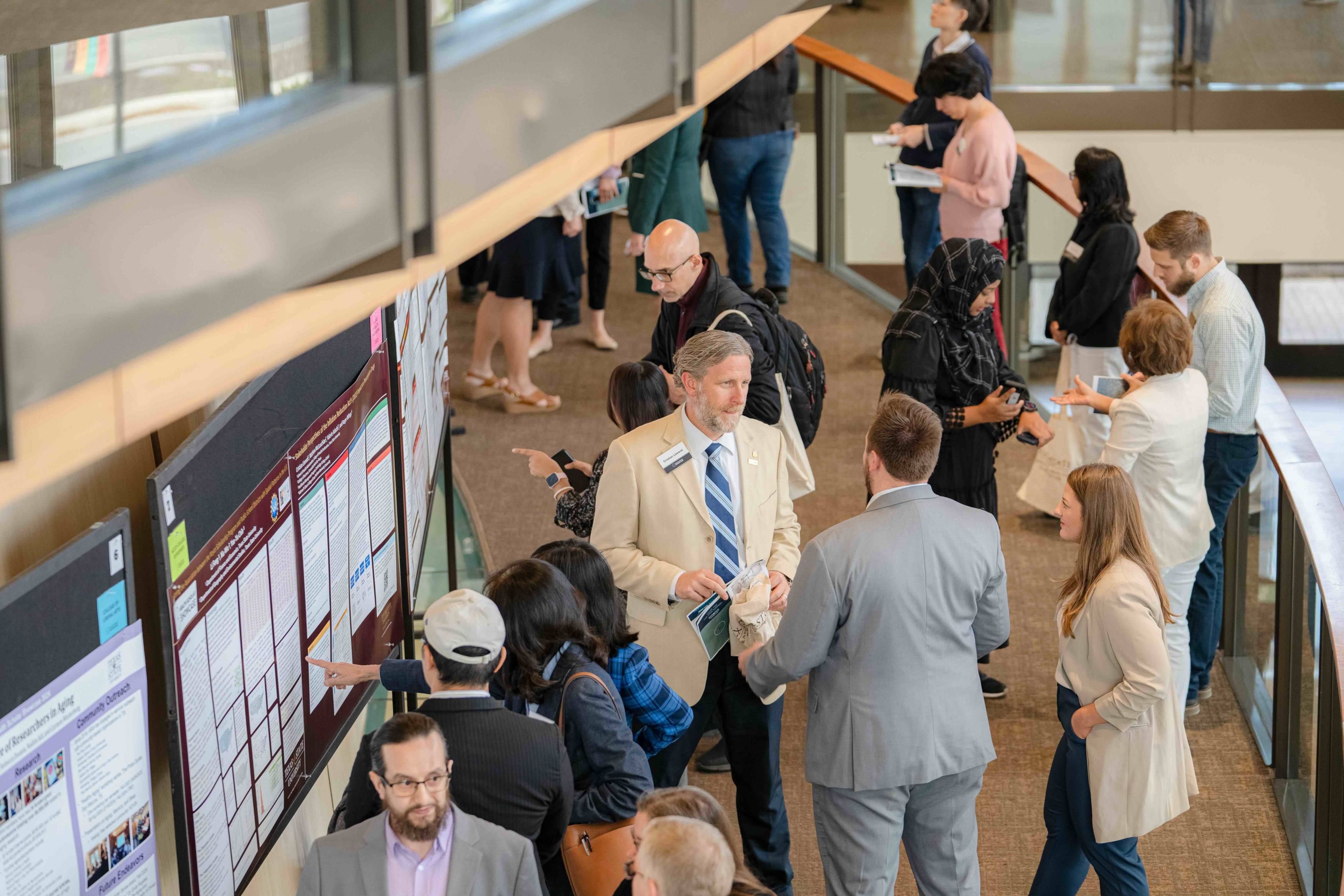 Attendees at the Health Scholar Showcase talk to poster presenters.