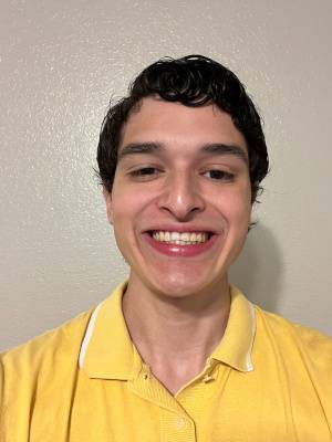 man wearing yellow shirt in front of off-white background