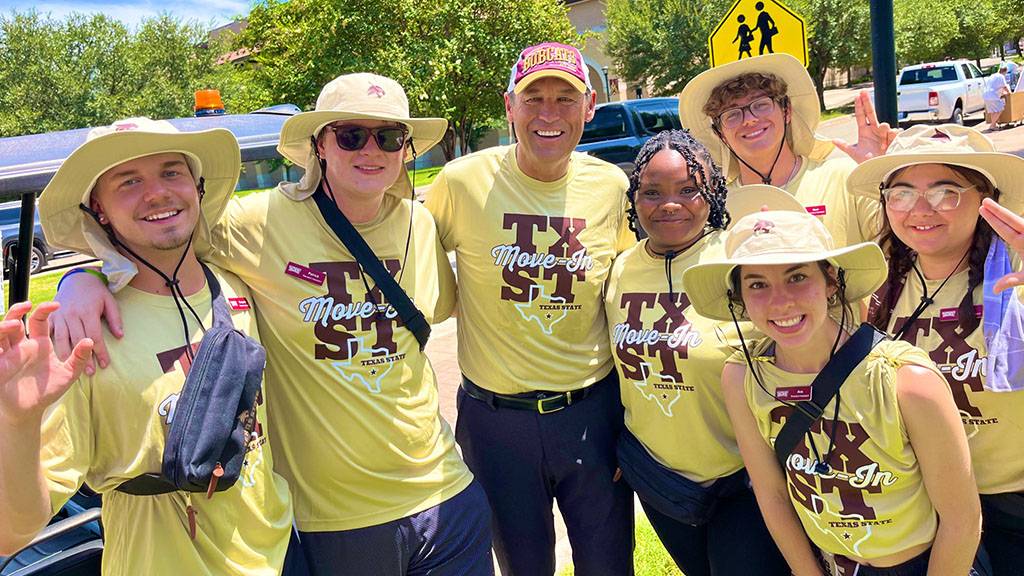 President Damphousse (middle) poses for a photo with a group of residence assistants during Move-in 2024.