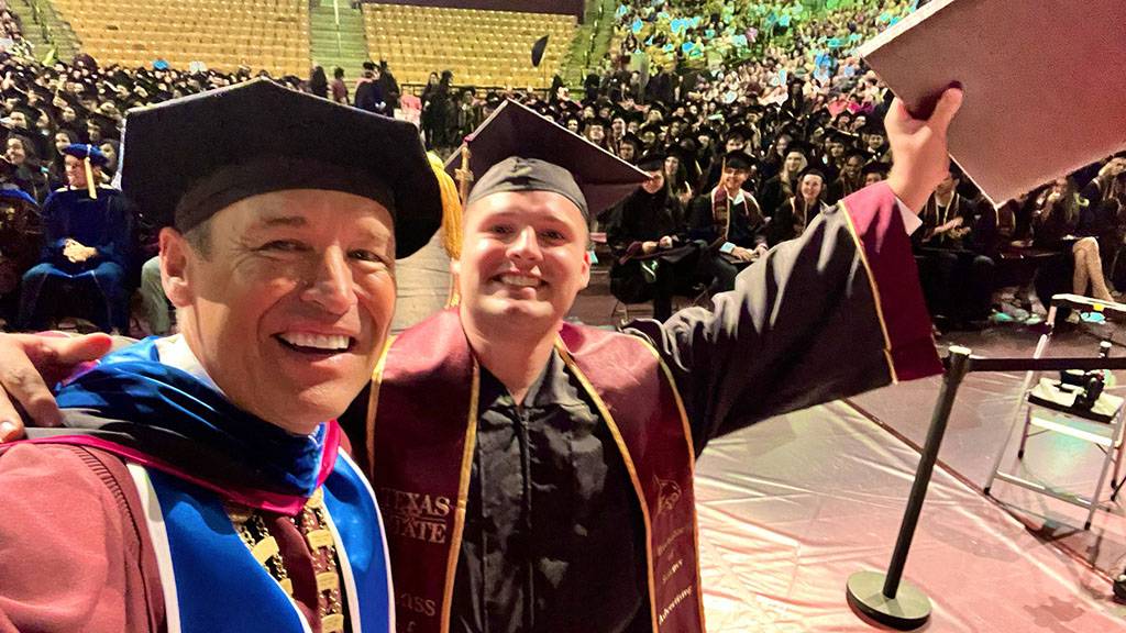 President Damphousse (left) poses for a photo with a new TXST graduate.