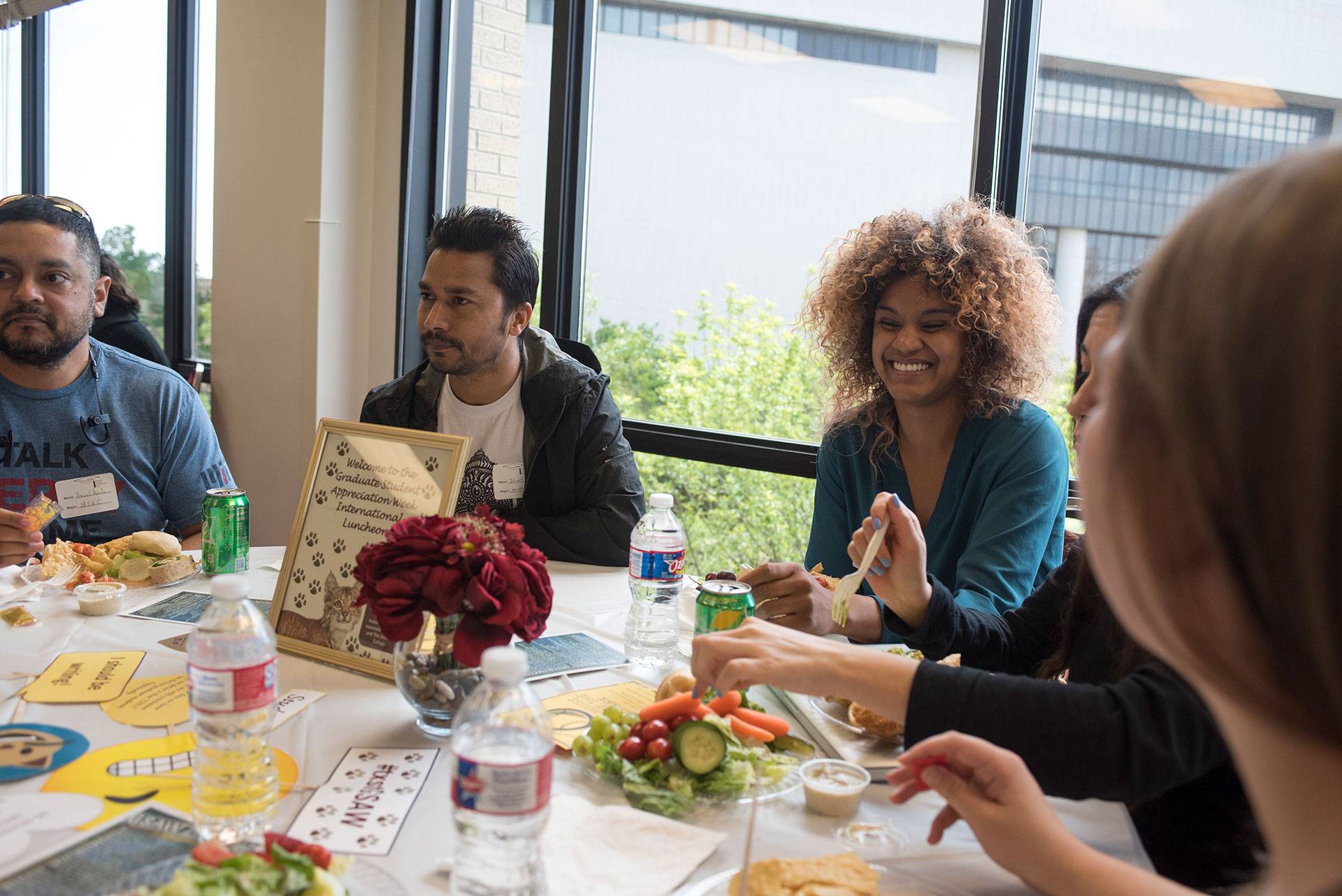 students sit at a table chatting during a luncheon