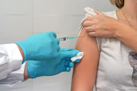 a person receiving a vaccine in the upper arm