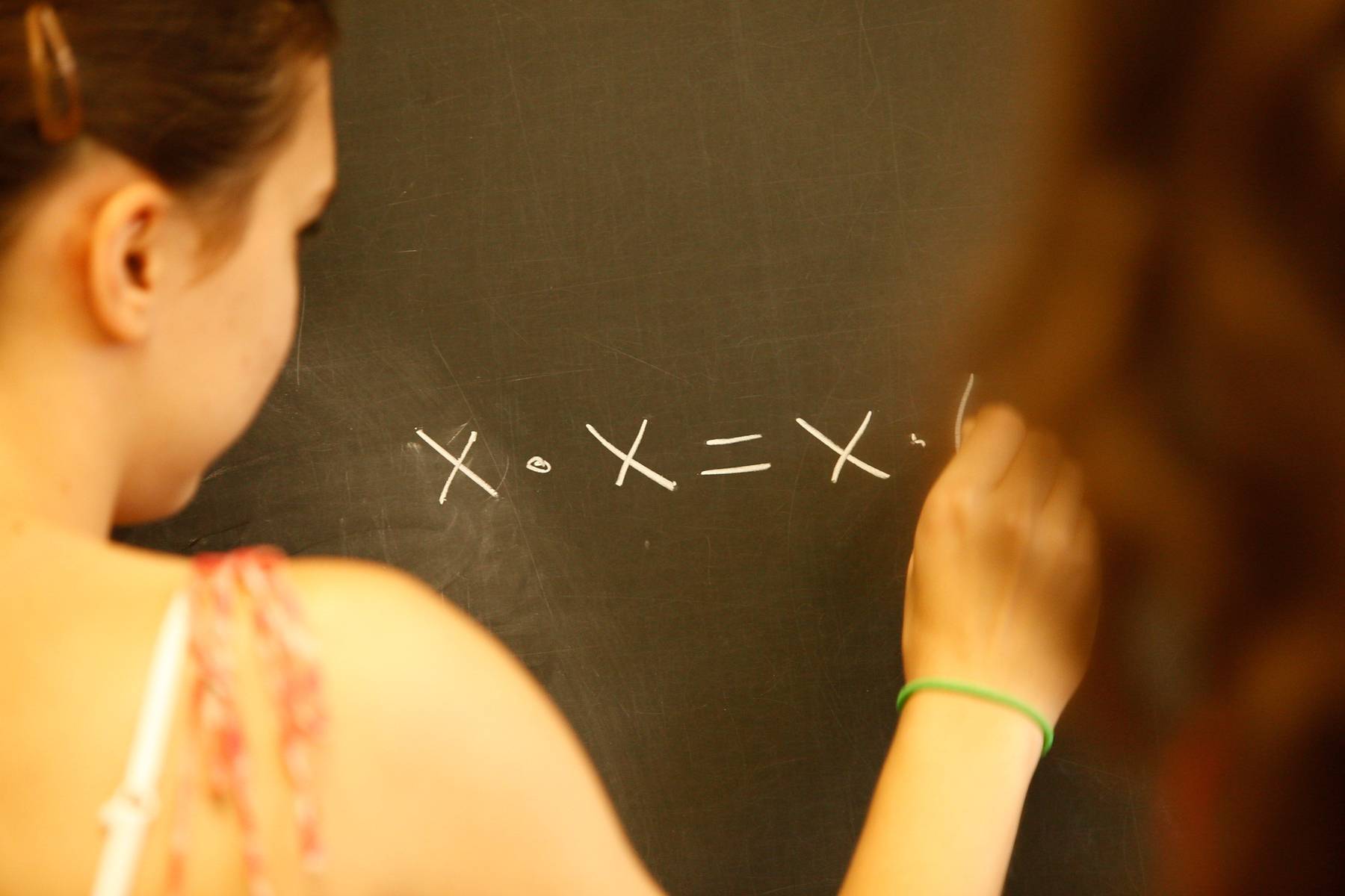 Math equation by girl at chalk board