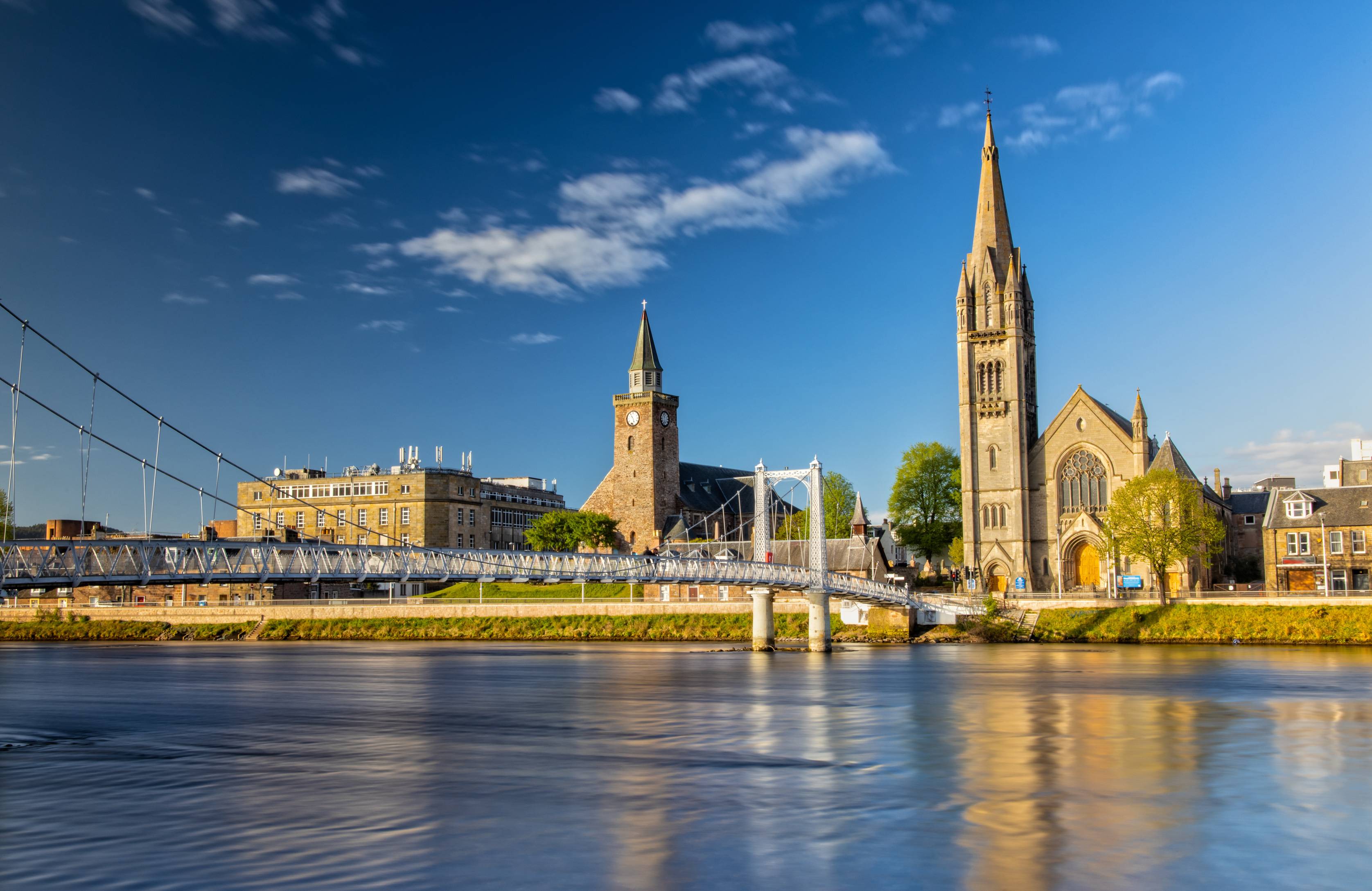 View of pedestrian Greig Street bridge across the River Ness and Old high St Stephen's church in background.