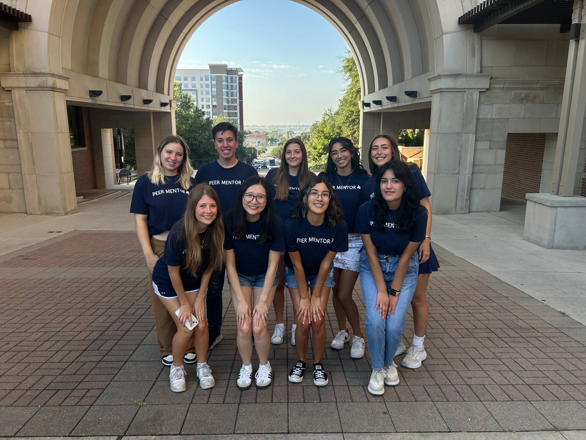 A group of peer mentors under the Trauth-Huffman Hall arch.