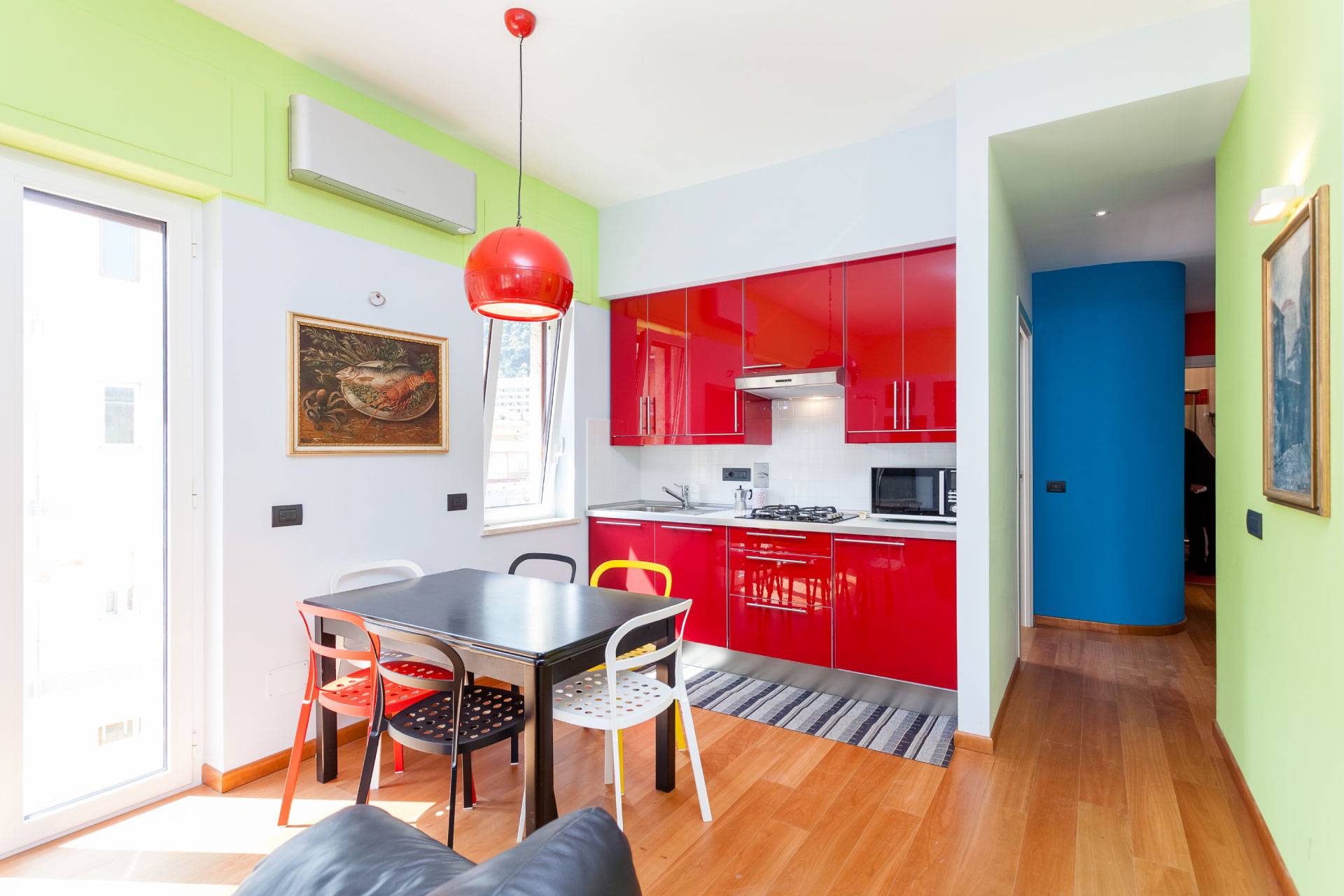 view of small brightly colored kitchen and dining tabling in Sant’Anna Institute Residence Apartments.