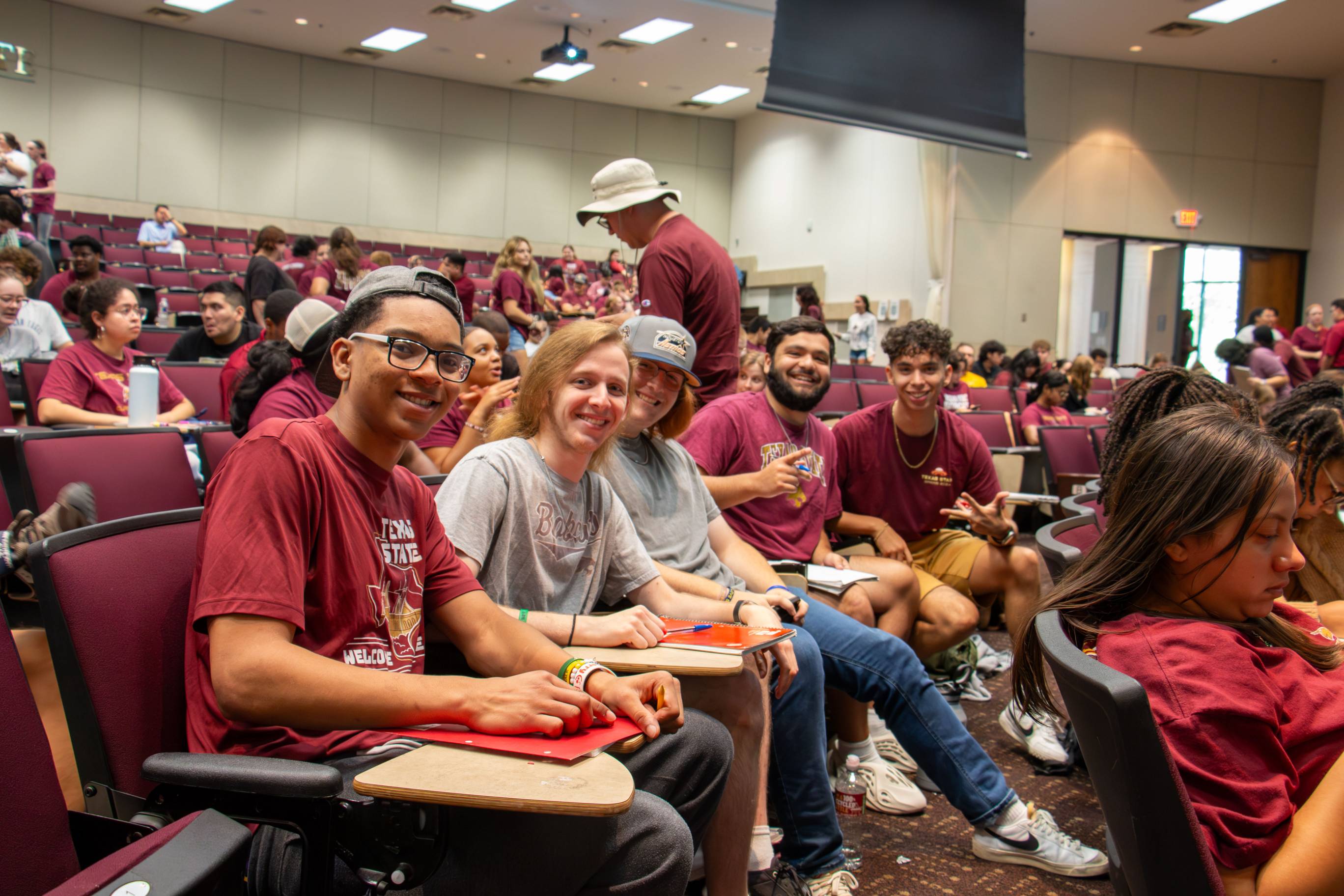 Students sitting in Alkek teaching theatre smiling