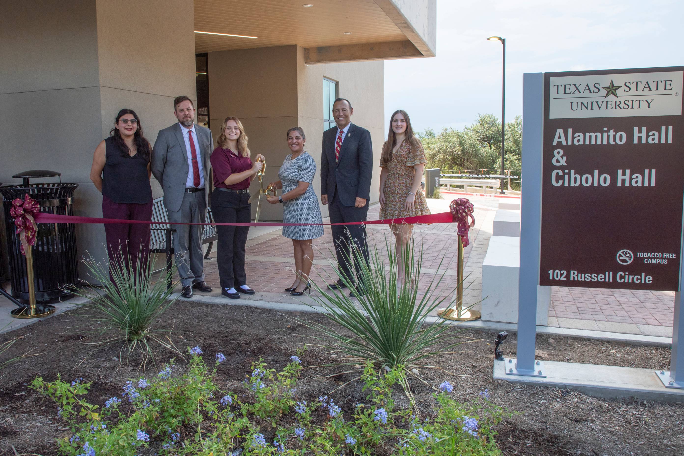 people participating in a ribbon cutting ceremony for residence halls