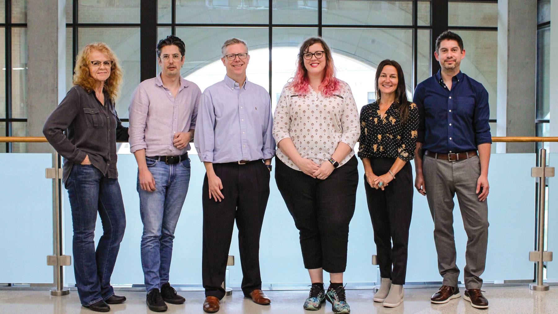 Five faculty fellow researchers stand and pose together.