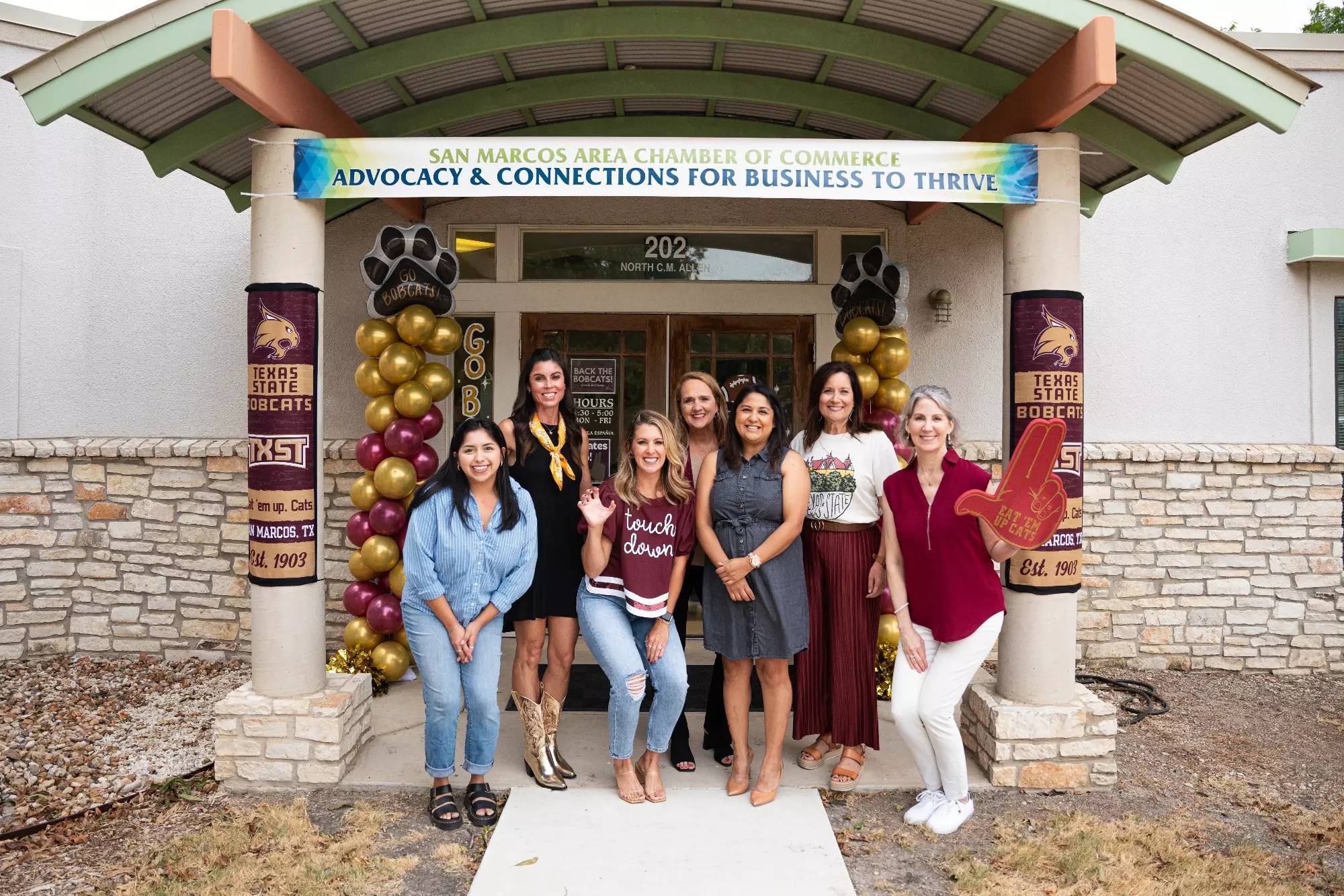 women posing for photo outside decorated building