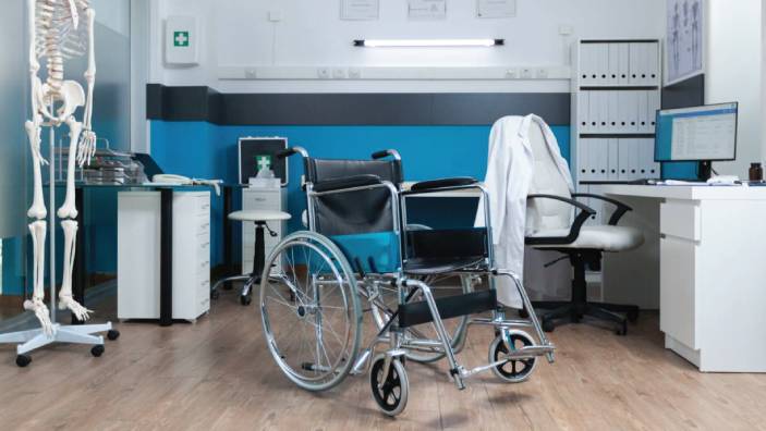 A wheelchair sits in a doctor's ofice.