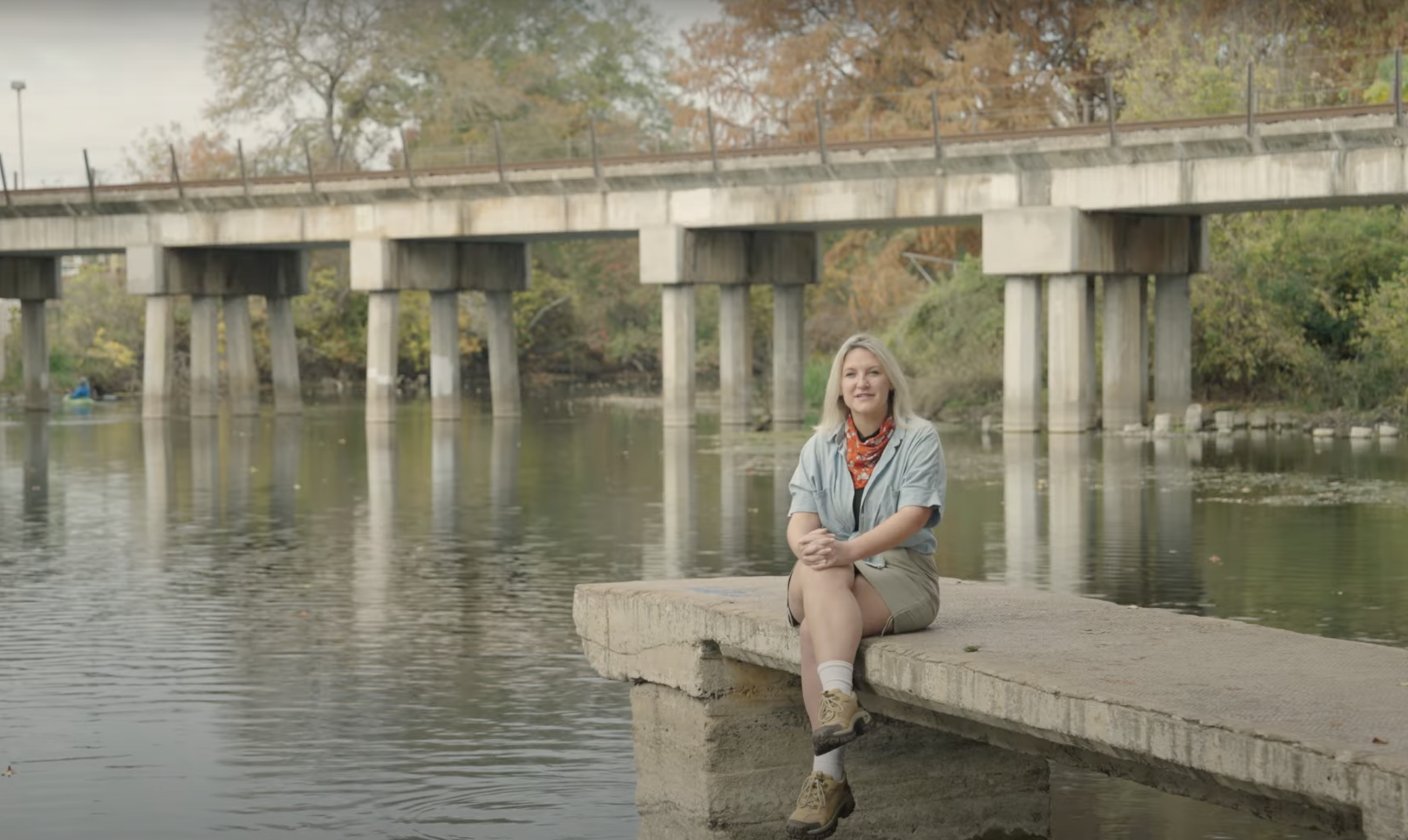 Kyndal Irwin, Ph.D candidate, sits with her legs cross at the end of a dock.