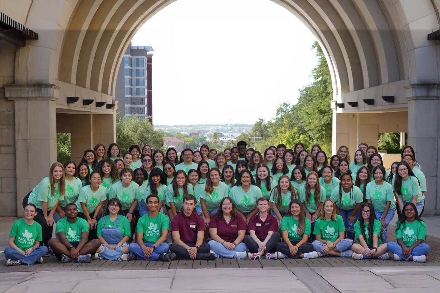 group in front of the TXST arch