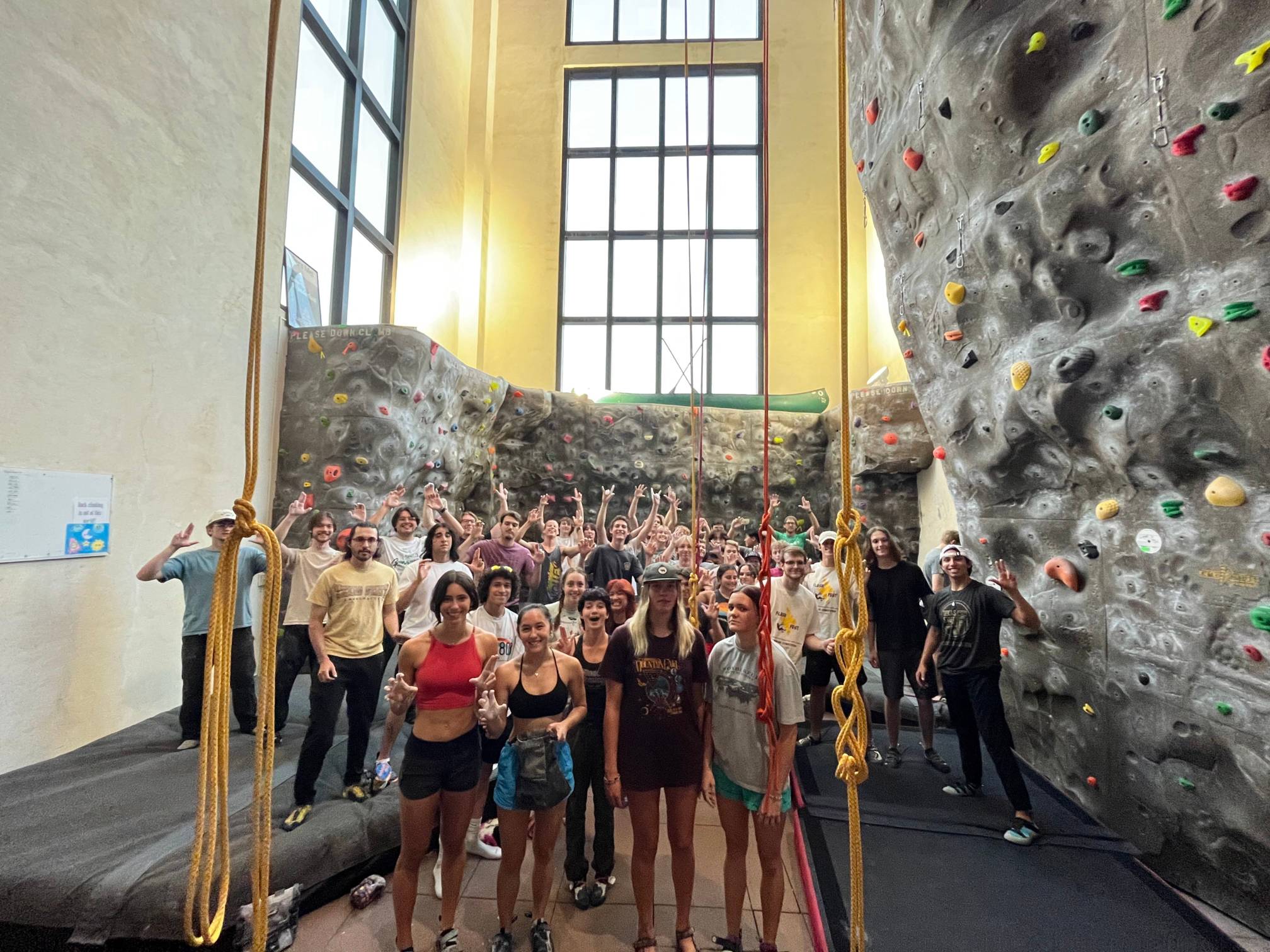 Climbing Sport Club team posing after a climbing meet in front of rock wall