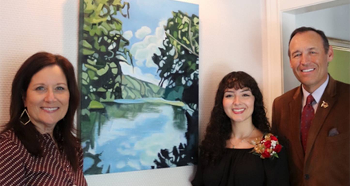 First Lady Beth (left) poses for a photo with Sofia Rodriguez and President Damphousse in front of Sofia's painting.