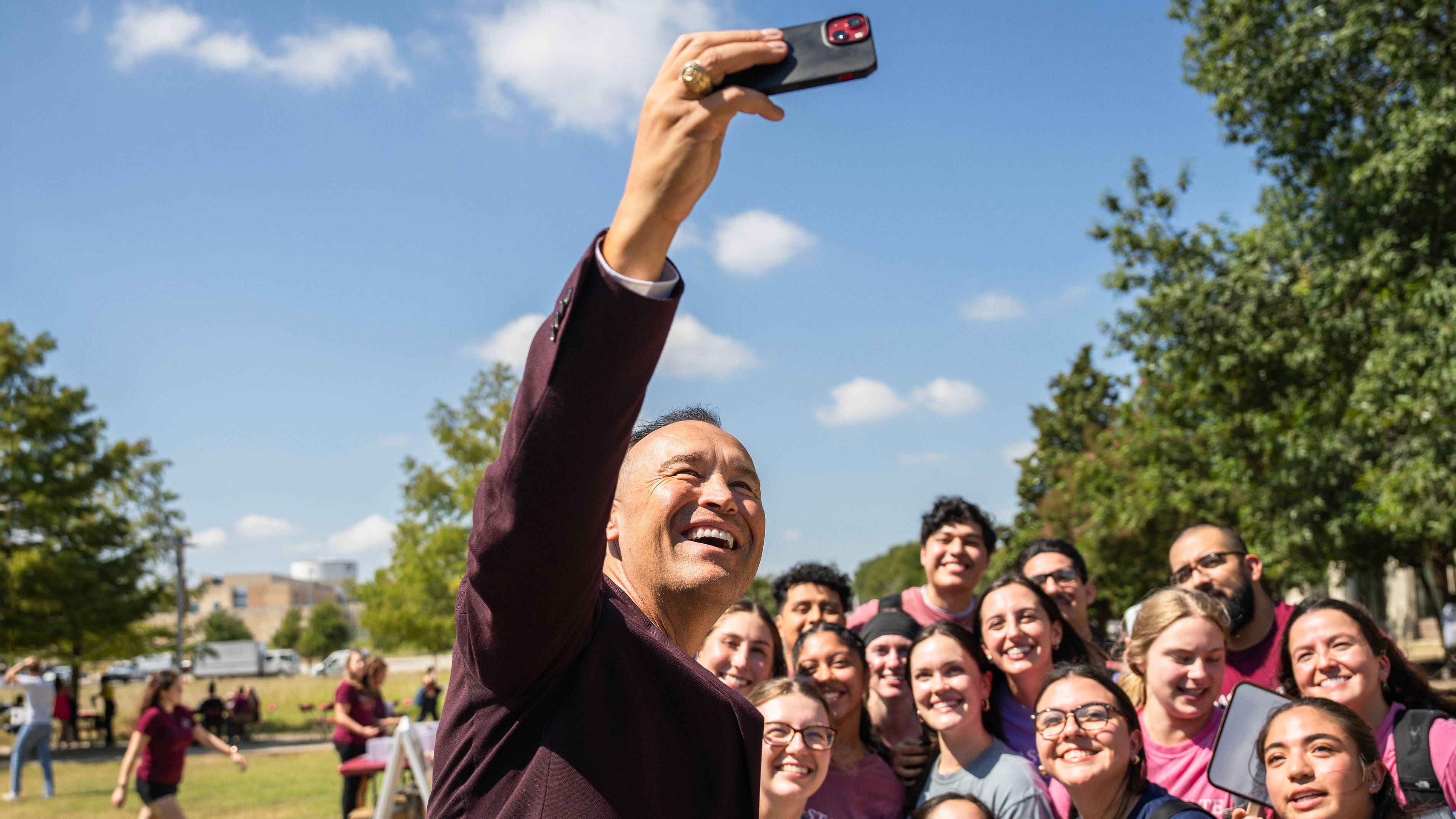 President Damphousse (left) takes a selfie with a group of students at the Round Rock Cookout.