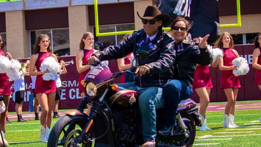 First Lady Beth (left) and President Kelly Damphousse pose for a photo with their Bobcat leather jackets at UFCU Stadium.