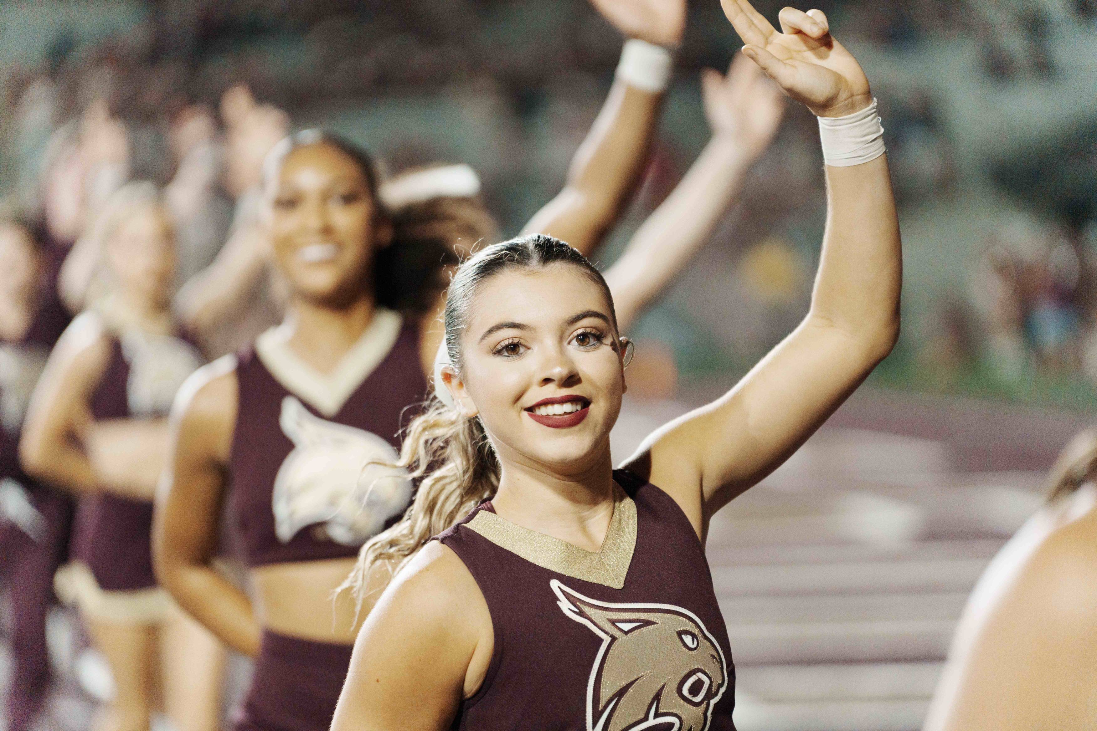 Cheerleaders in uniform lined up mid-performance