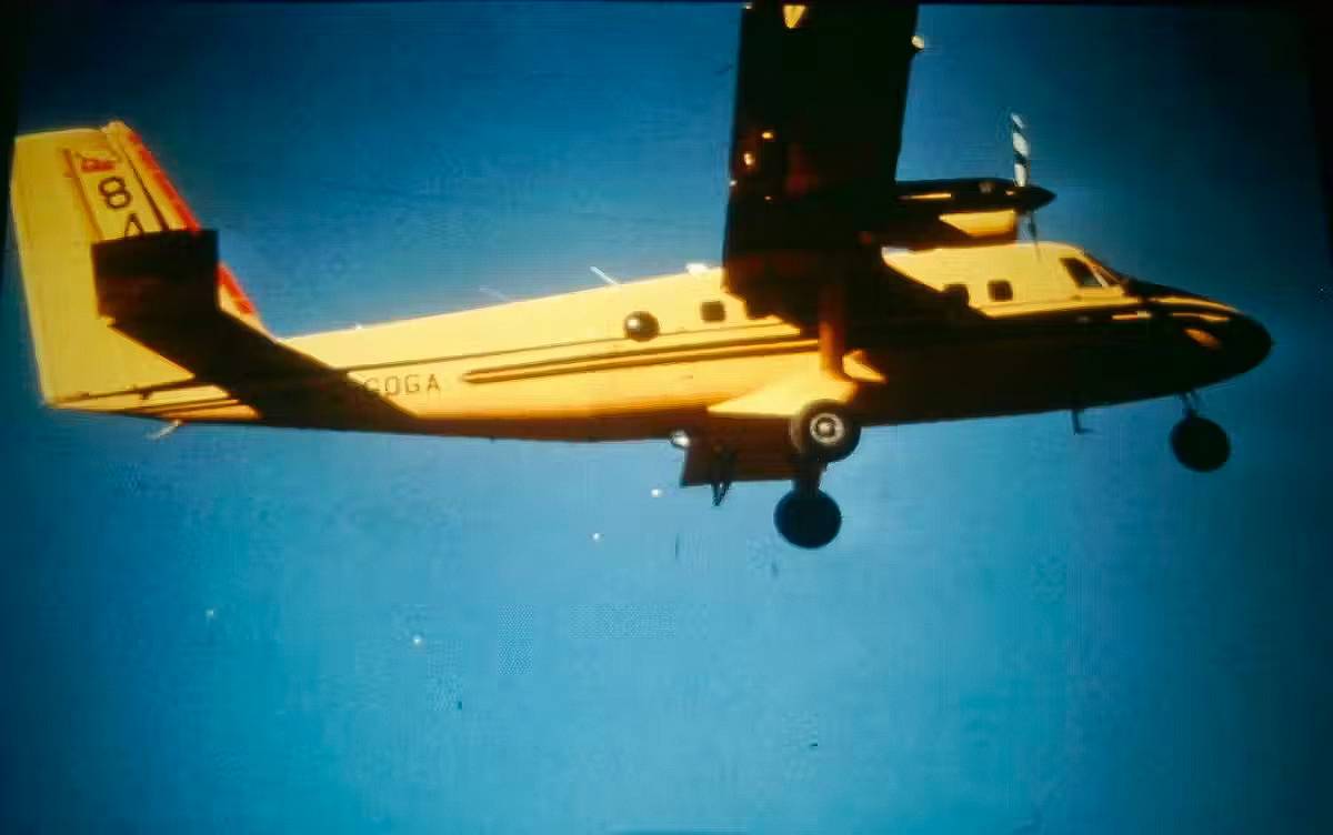 a yellow plane flying in the air