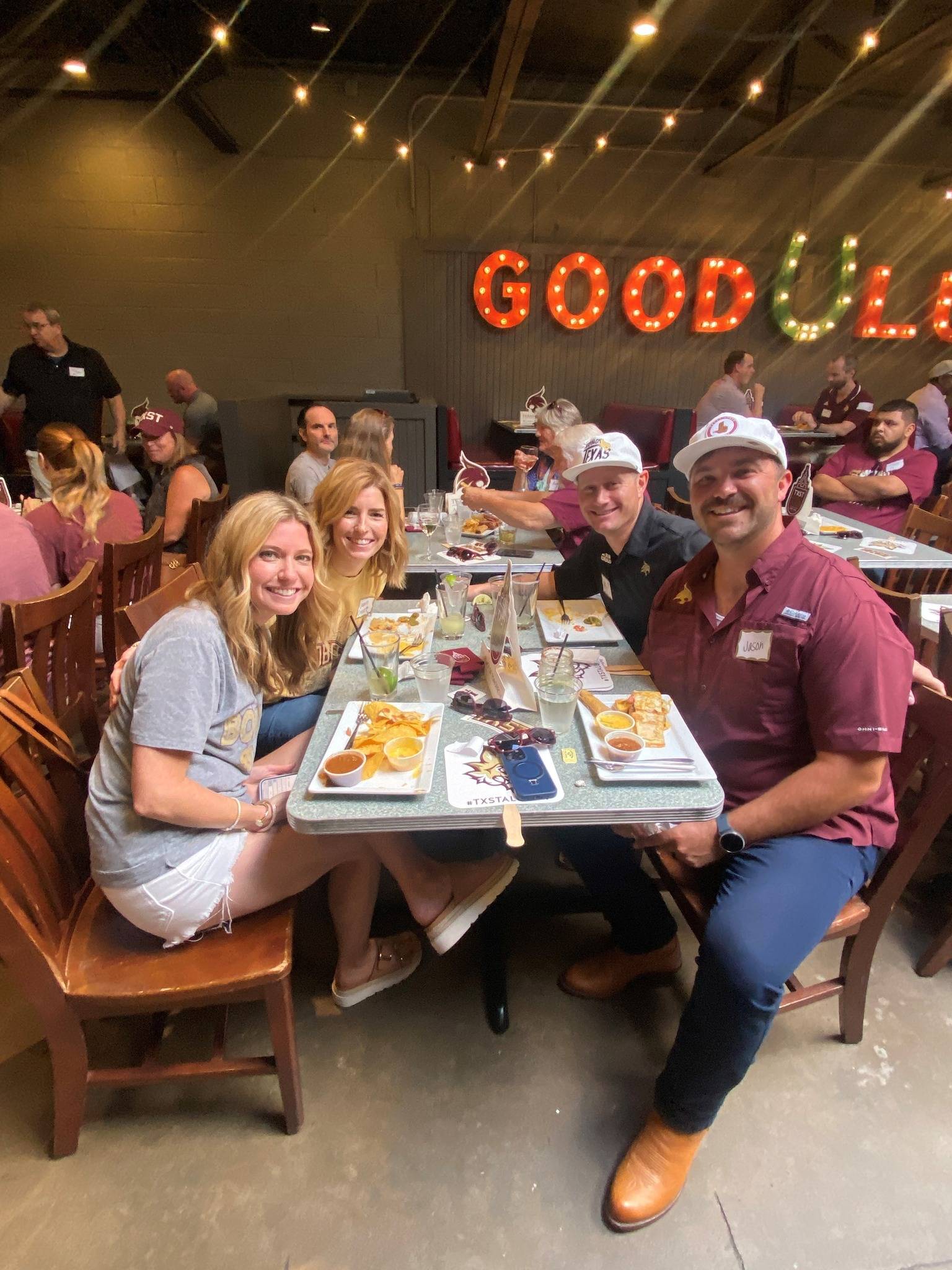 Group of Texas State fans sitting at a table during a watch party