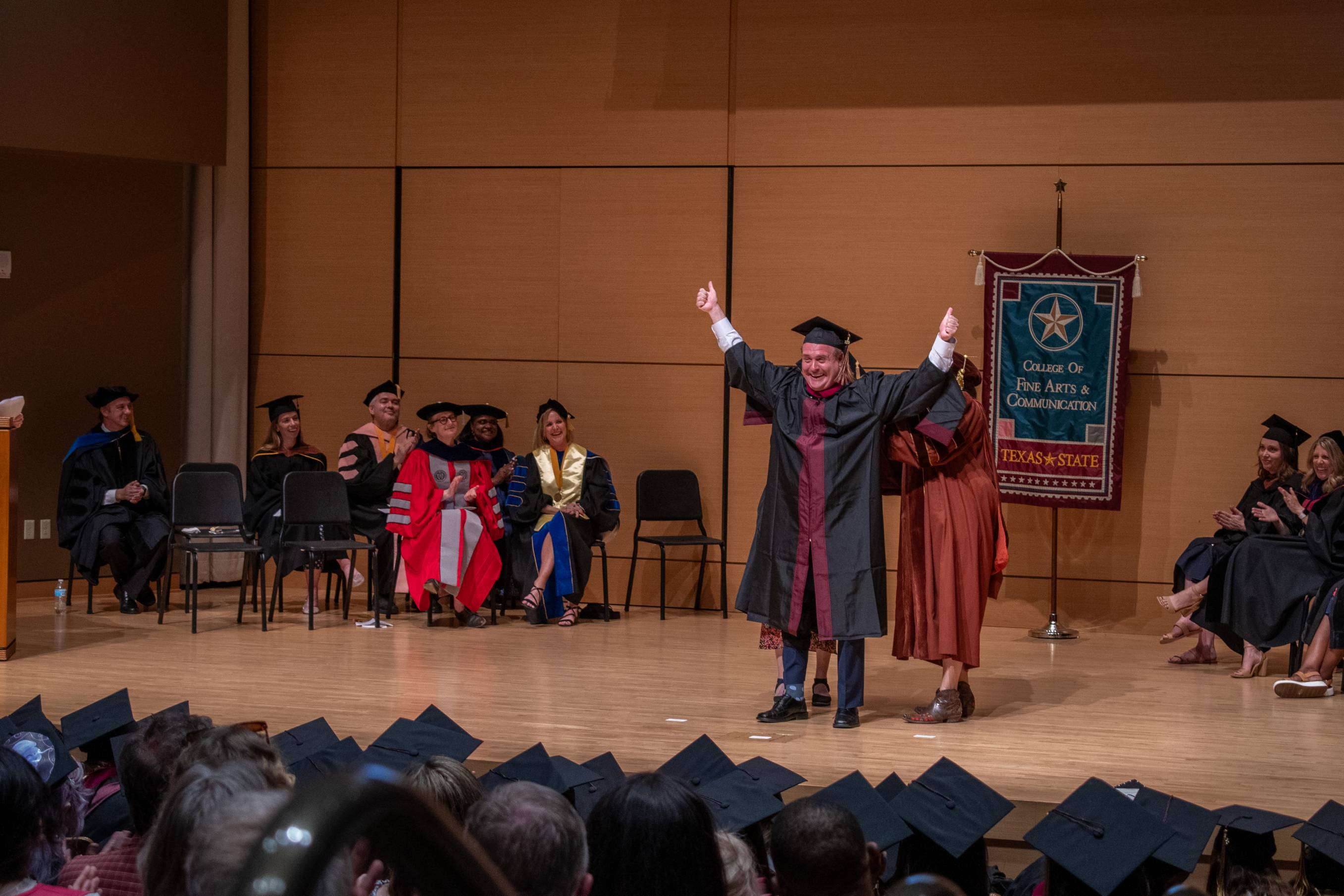 A student in joy at the Masters Hooding Ceremony