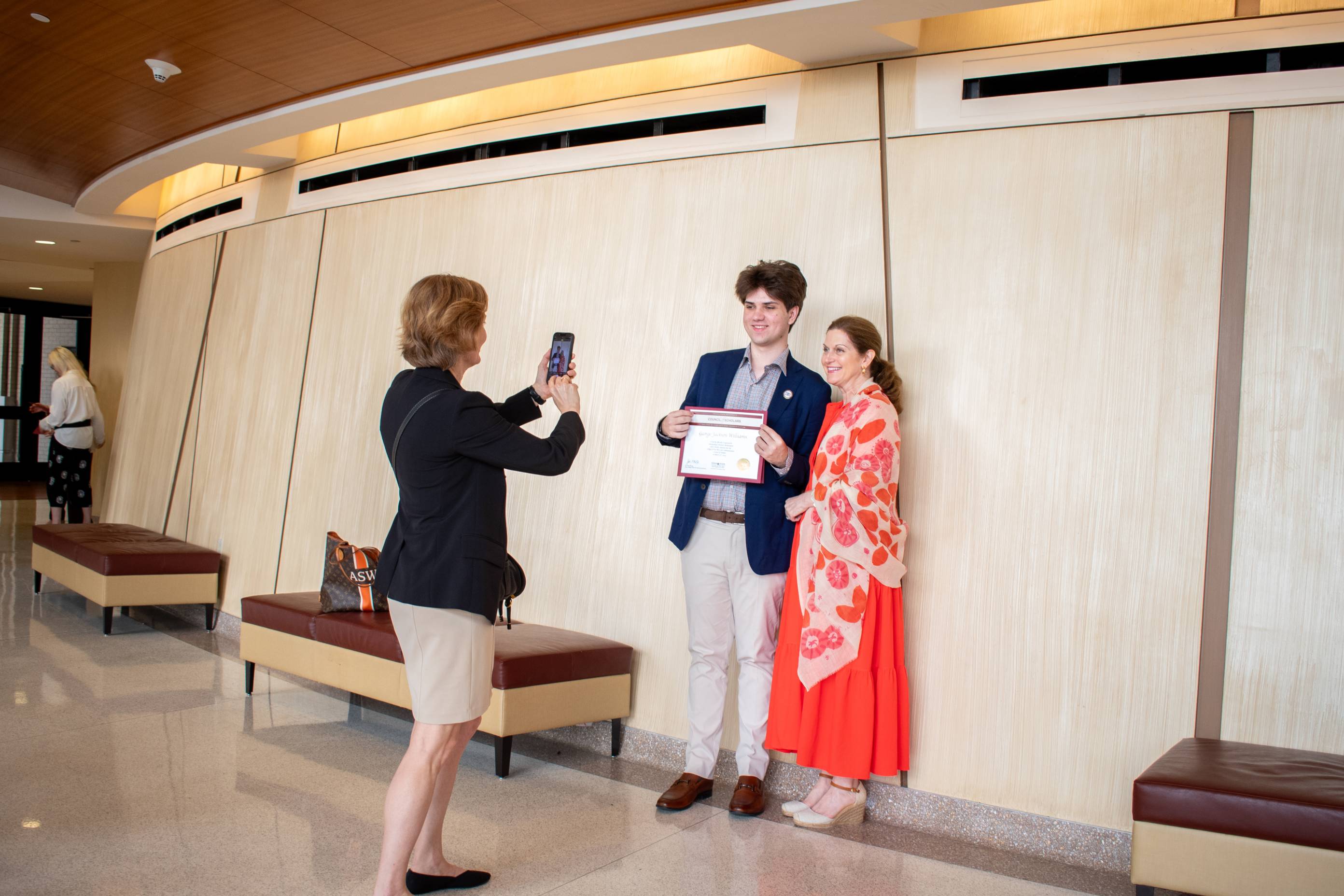 a student poses with a family member after the council of scholars ceremony 