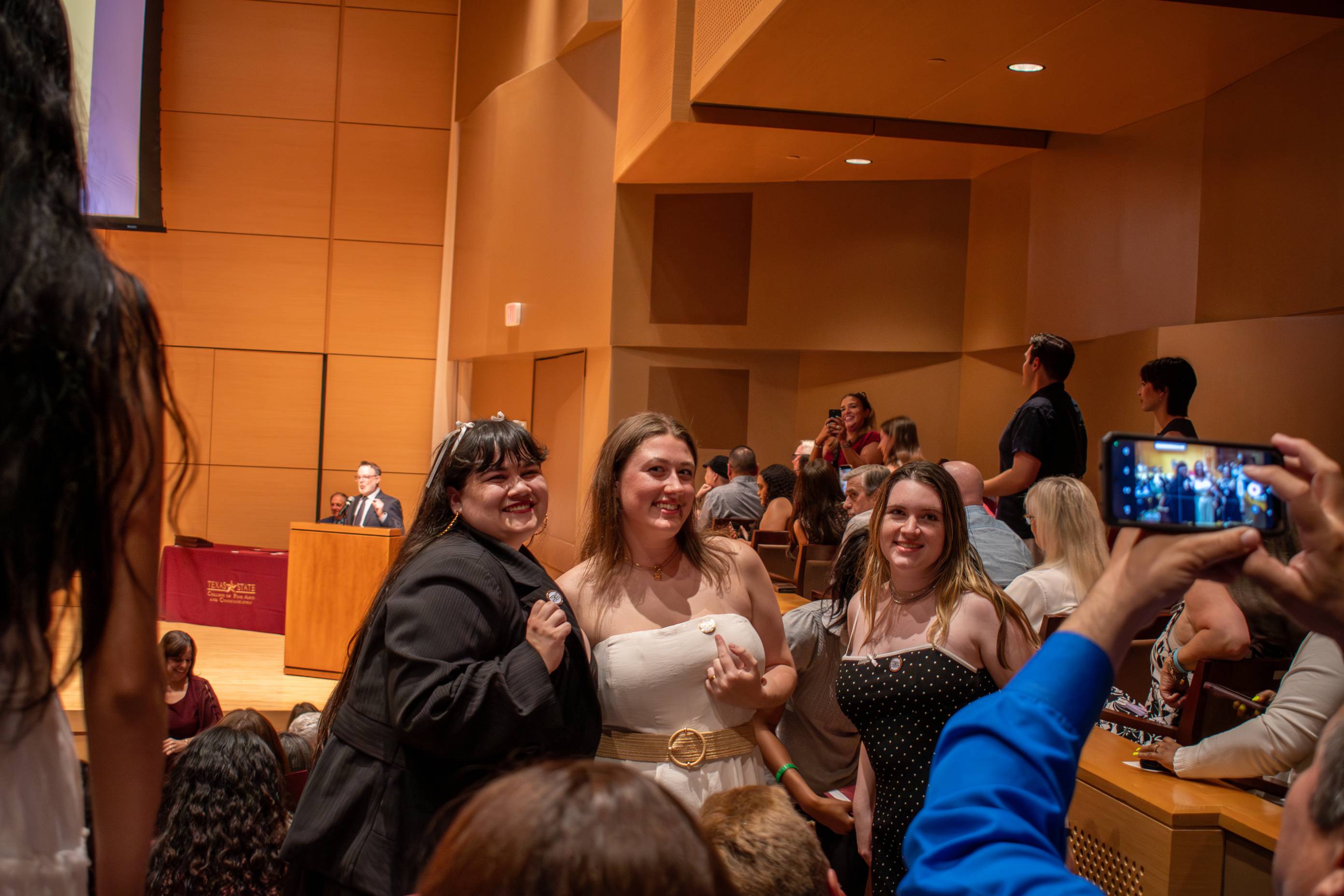 a photo of three students who are posing during the council of scholars ceremony