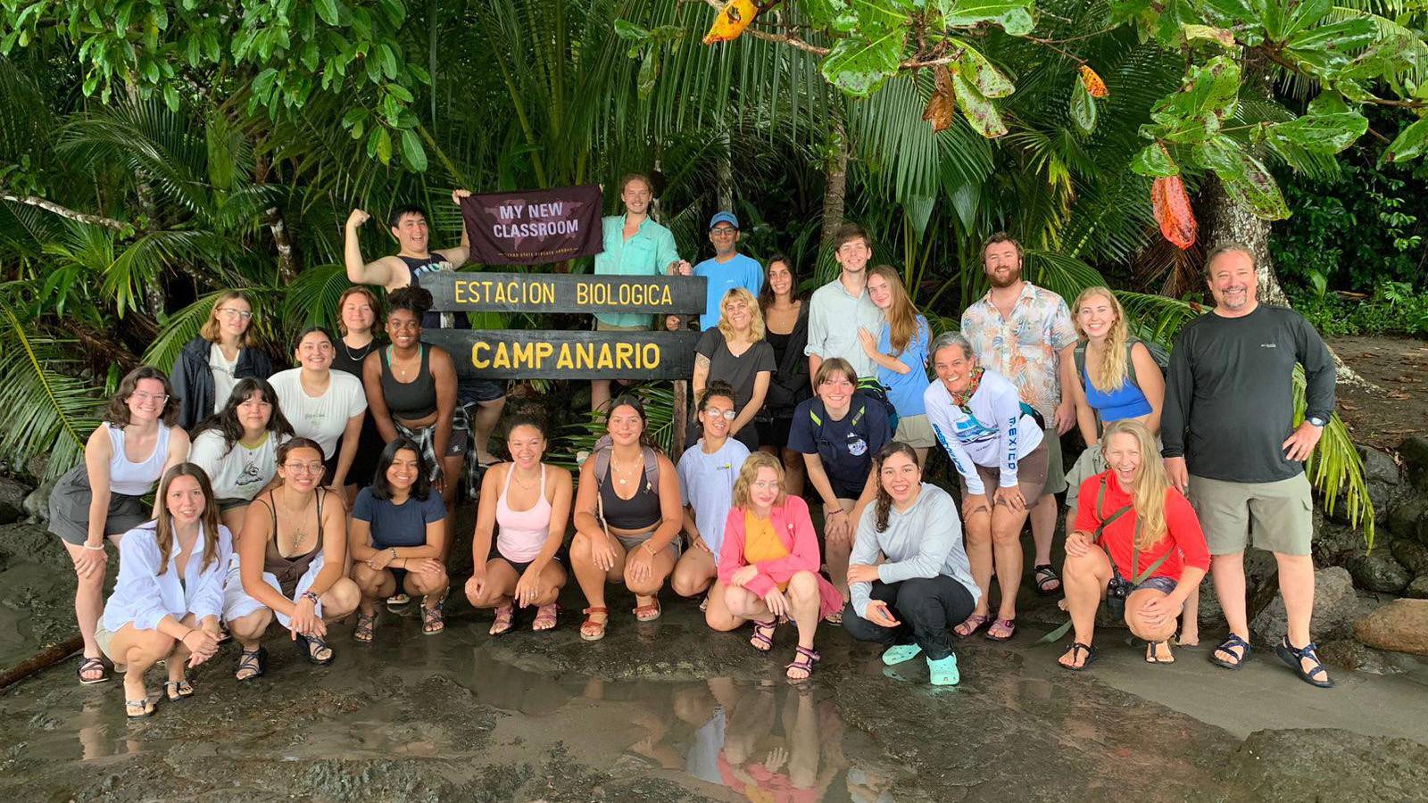 A group of students in a study abroad program pose for a photo in Costa Rica with a TXST flag.