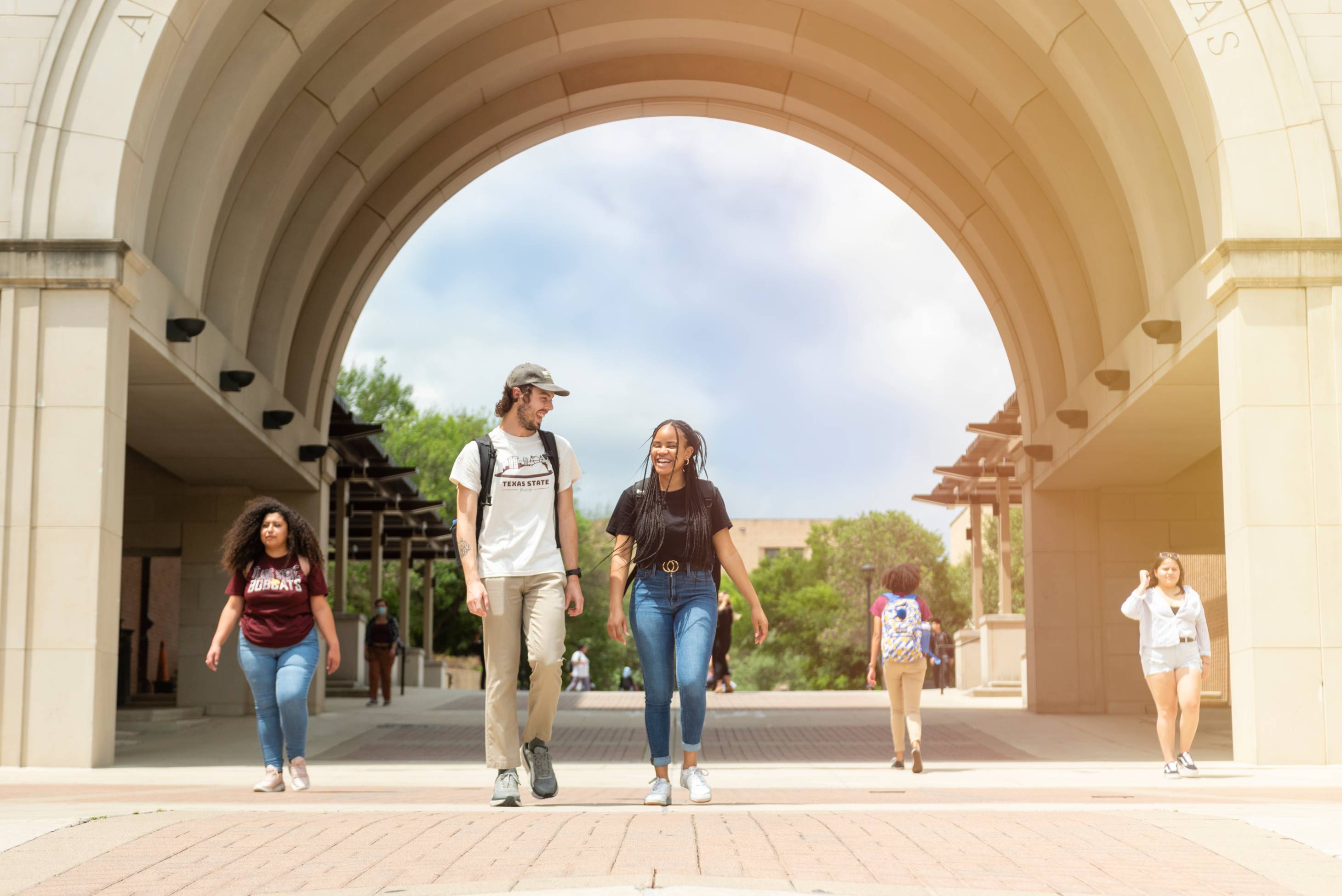 students walking under the UAC arch