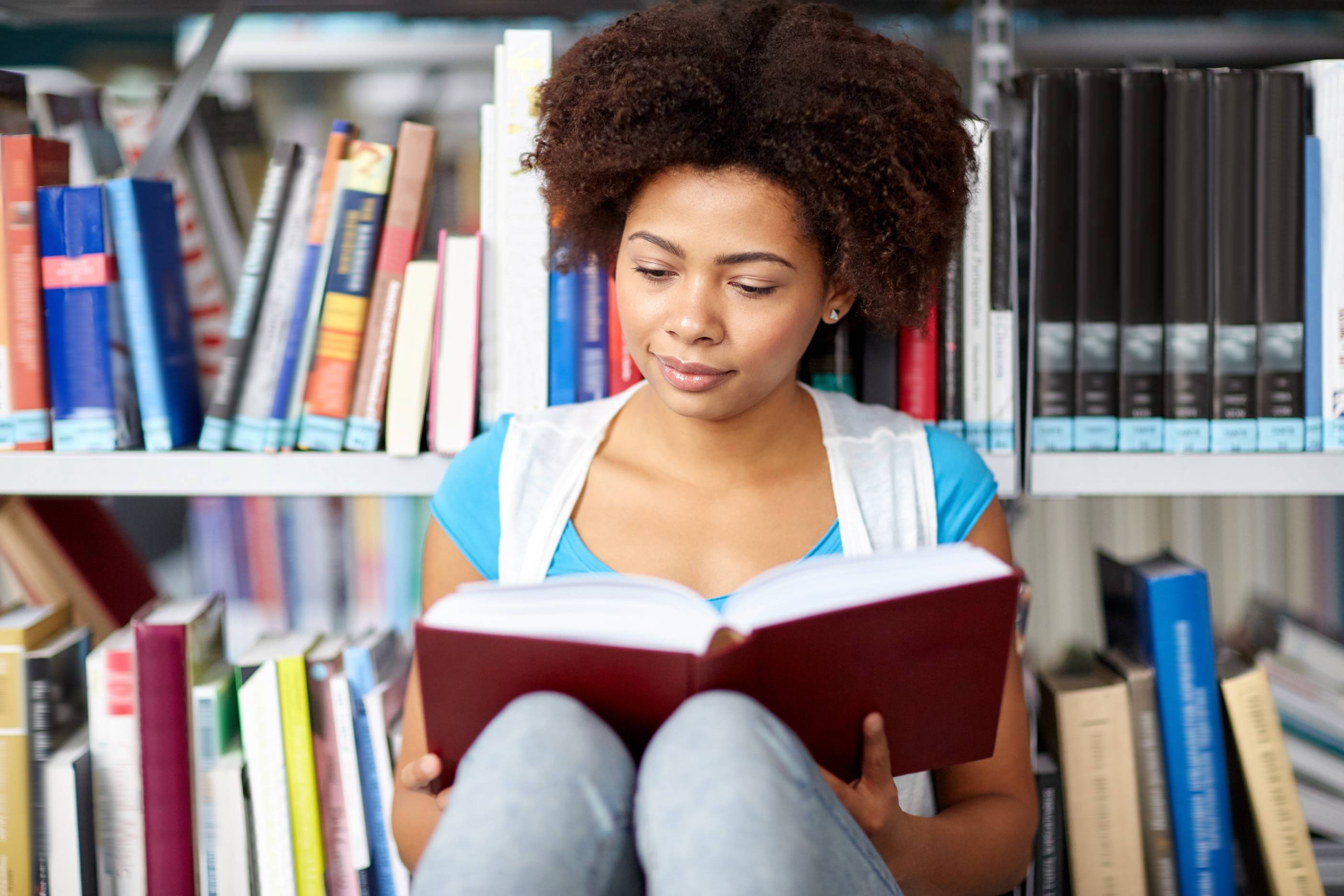 A student reading a book in a library