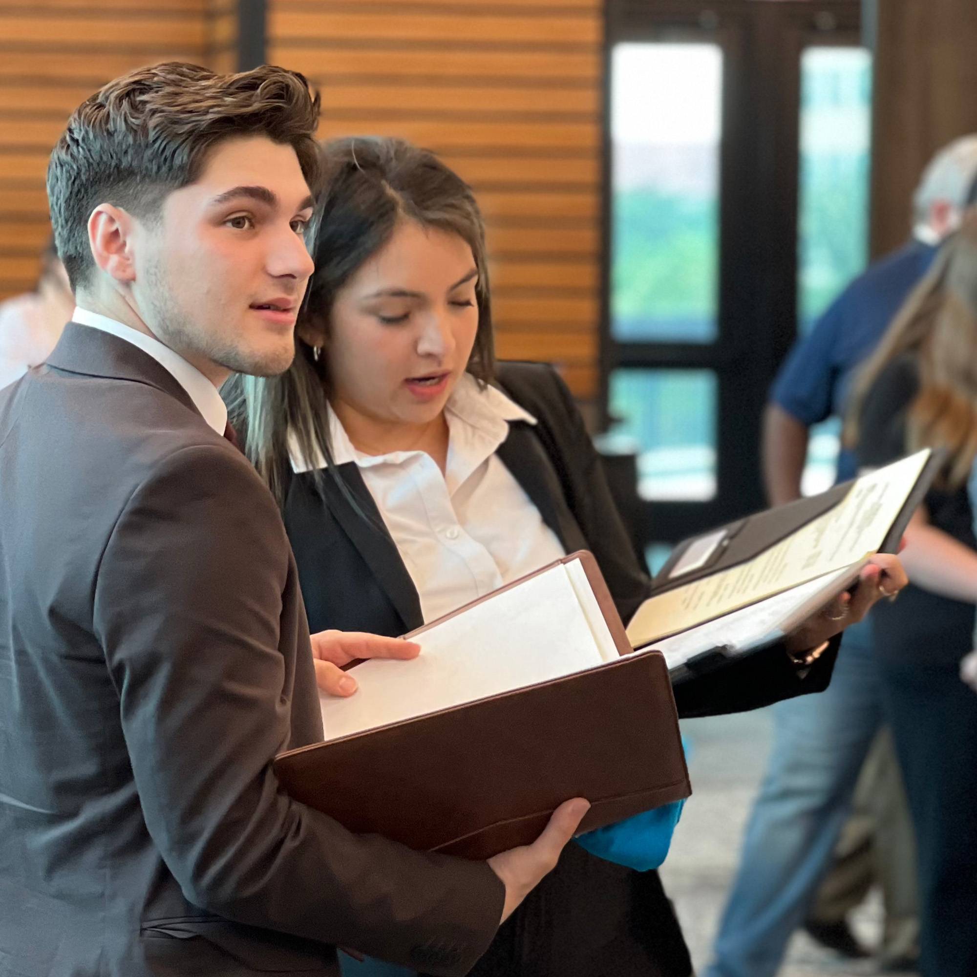 Two students in business attire at recruiting event