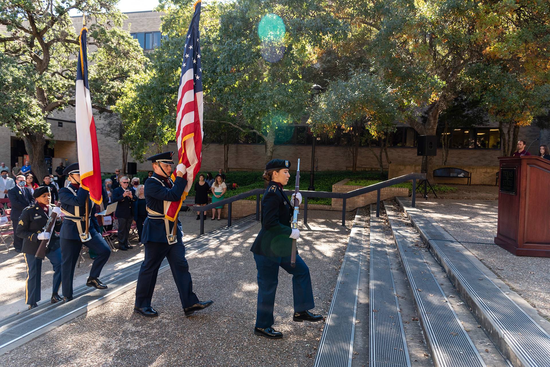 rotc members carrying an american flag