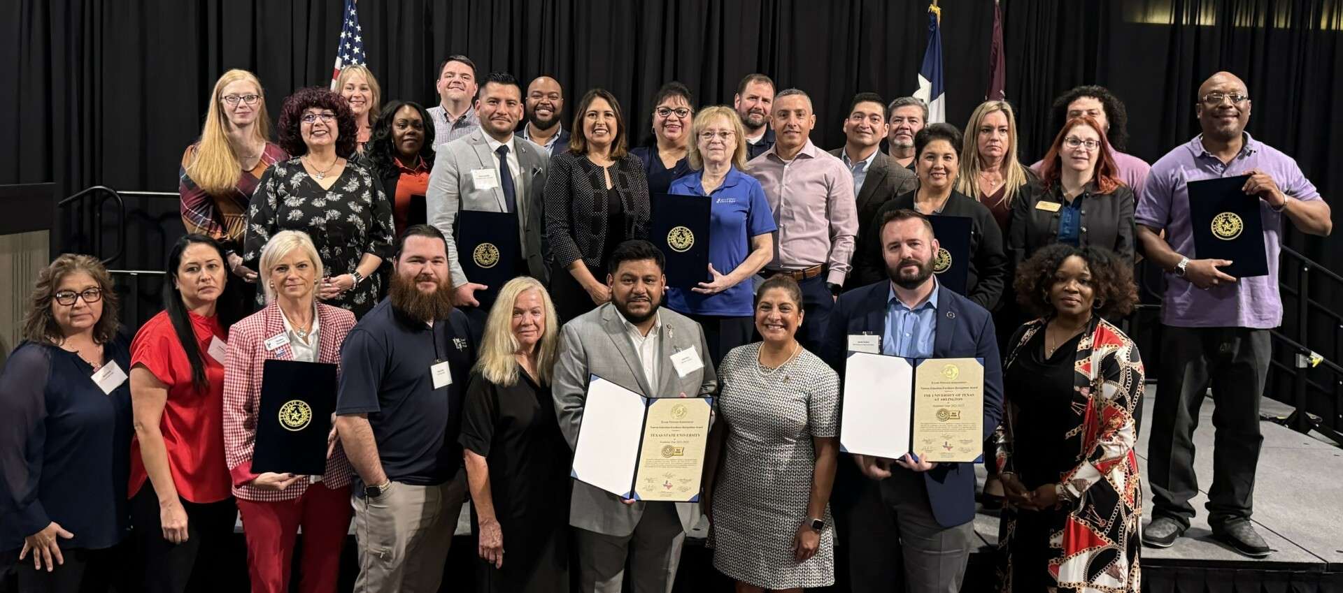 people standing in a group holding certificates at an awards ceremony