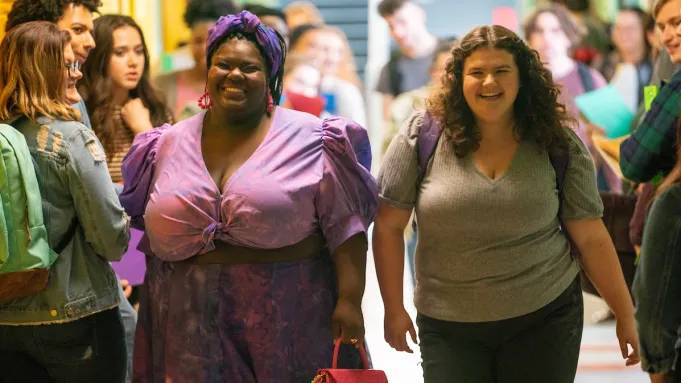 Jemima Yevu (left) walks next to Mia Kaplan through a school hallway in a scene from the movie Empire Waist.