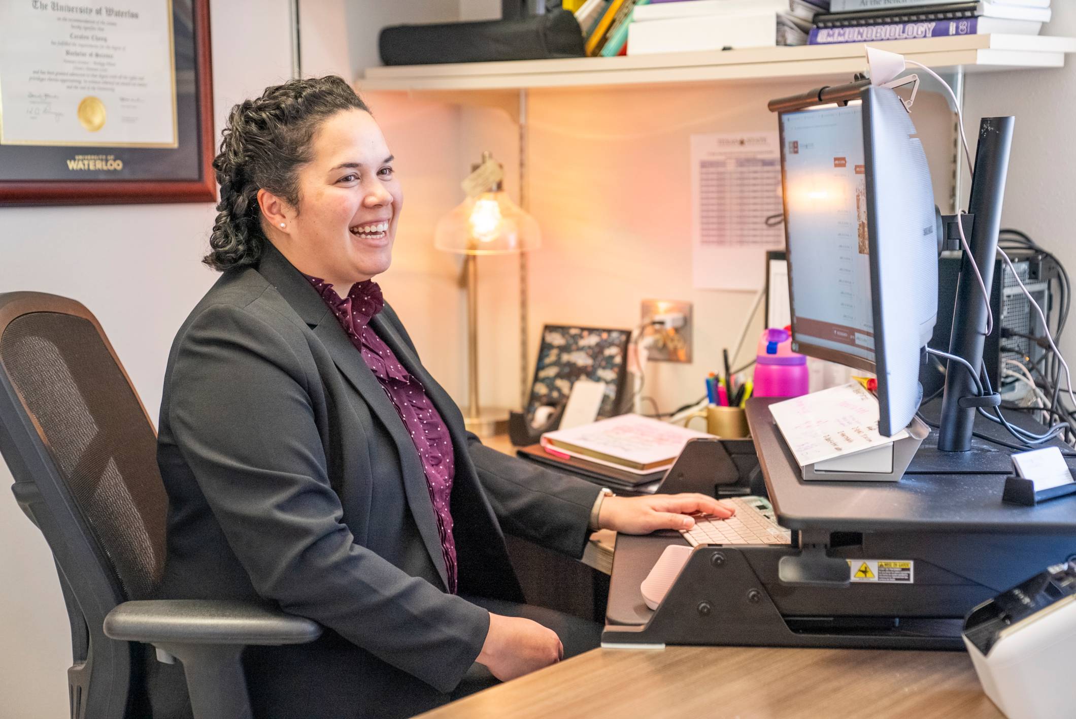 A photo of Faculty Fellow, Dr. Carolyn Chang sitting in front of her computer.