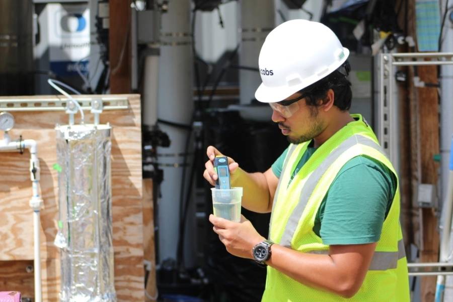 An image of a graduate student testing water at the San Marcis Wastewater Treatment Plant.