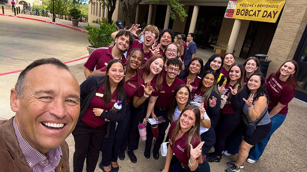 President Damphousse (left) poses for a photo with a group of students workers during a recent Bobcat Day.