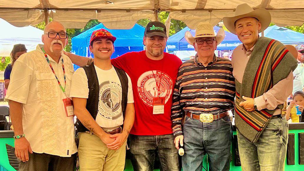 TXST President Kelly Damphousse (left) poses for a photo with Sacred Springs Powwow attendees.