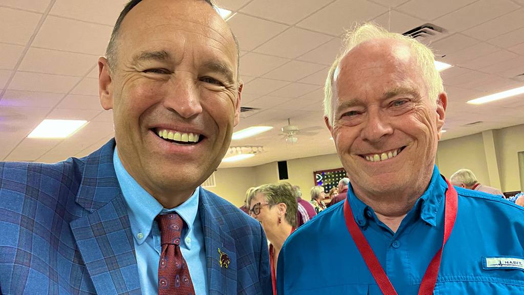 President Kelly Damphousse (left) poses for a photo with a retired staff member.