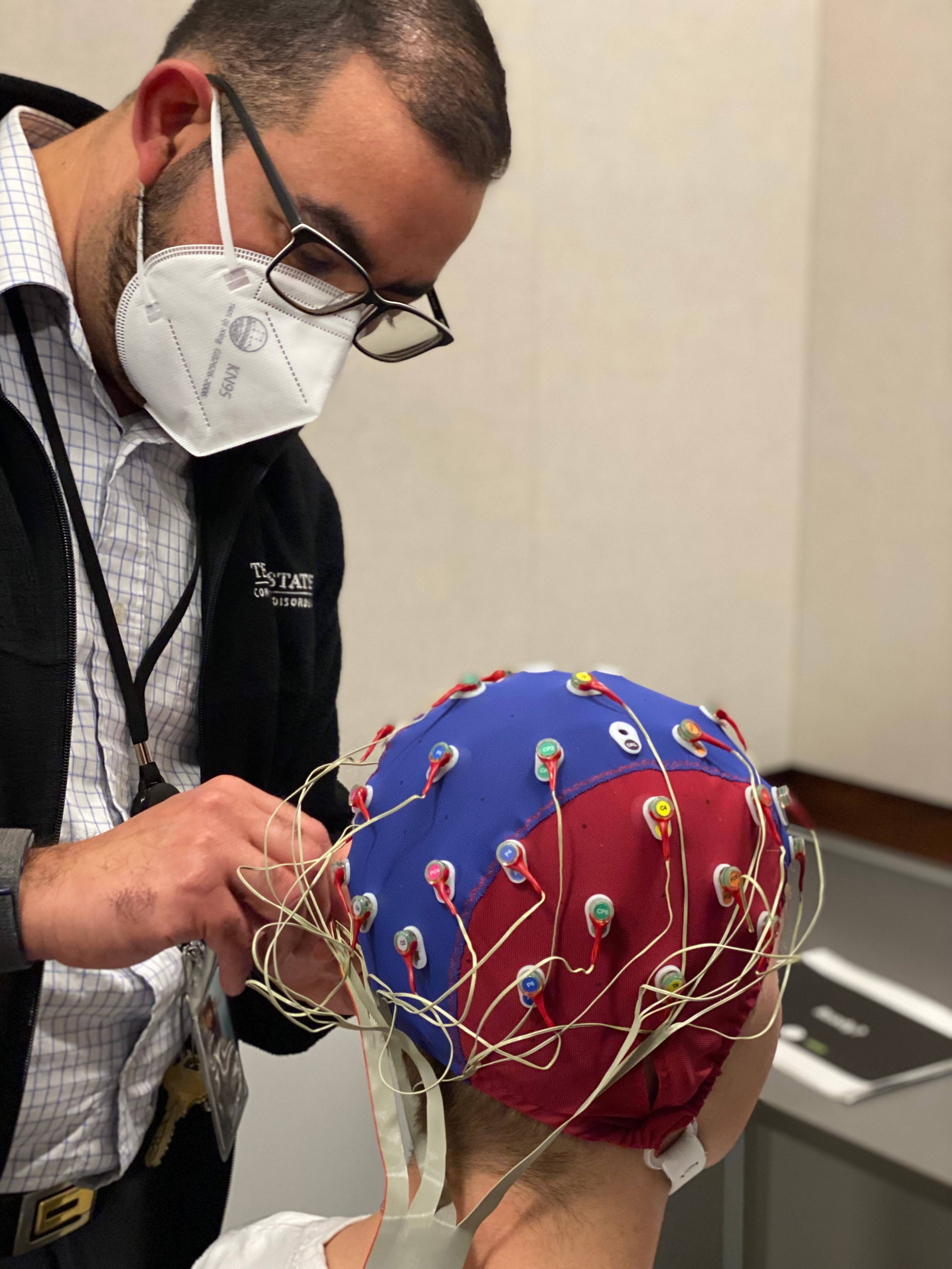 Student clinicians interacting with a patient in one of the speech therapy rooms.