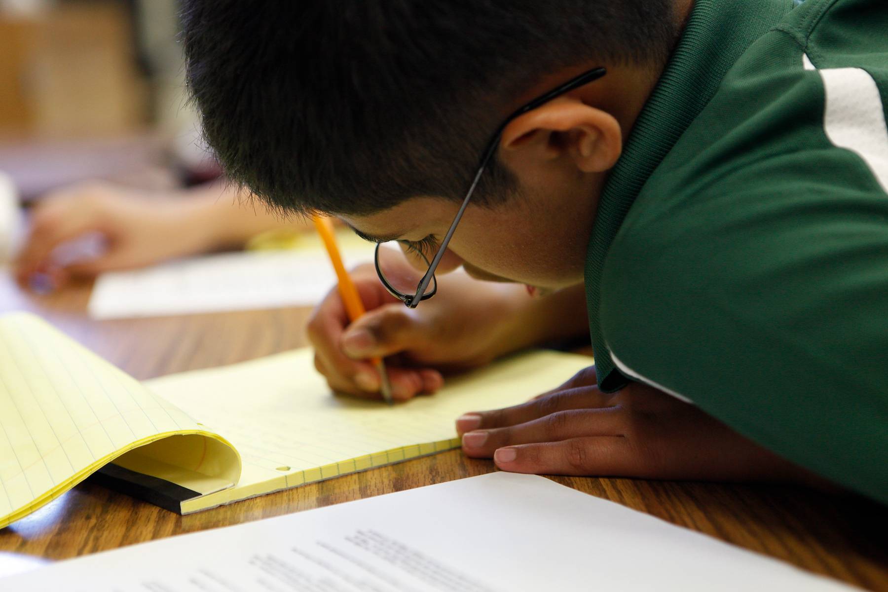 Young Man working a math problem on paper
