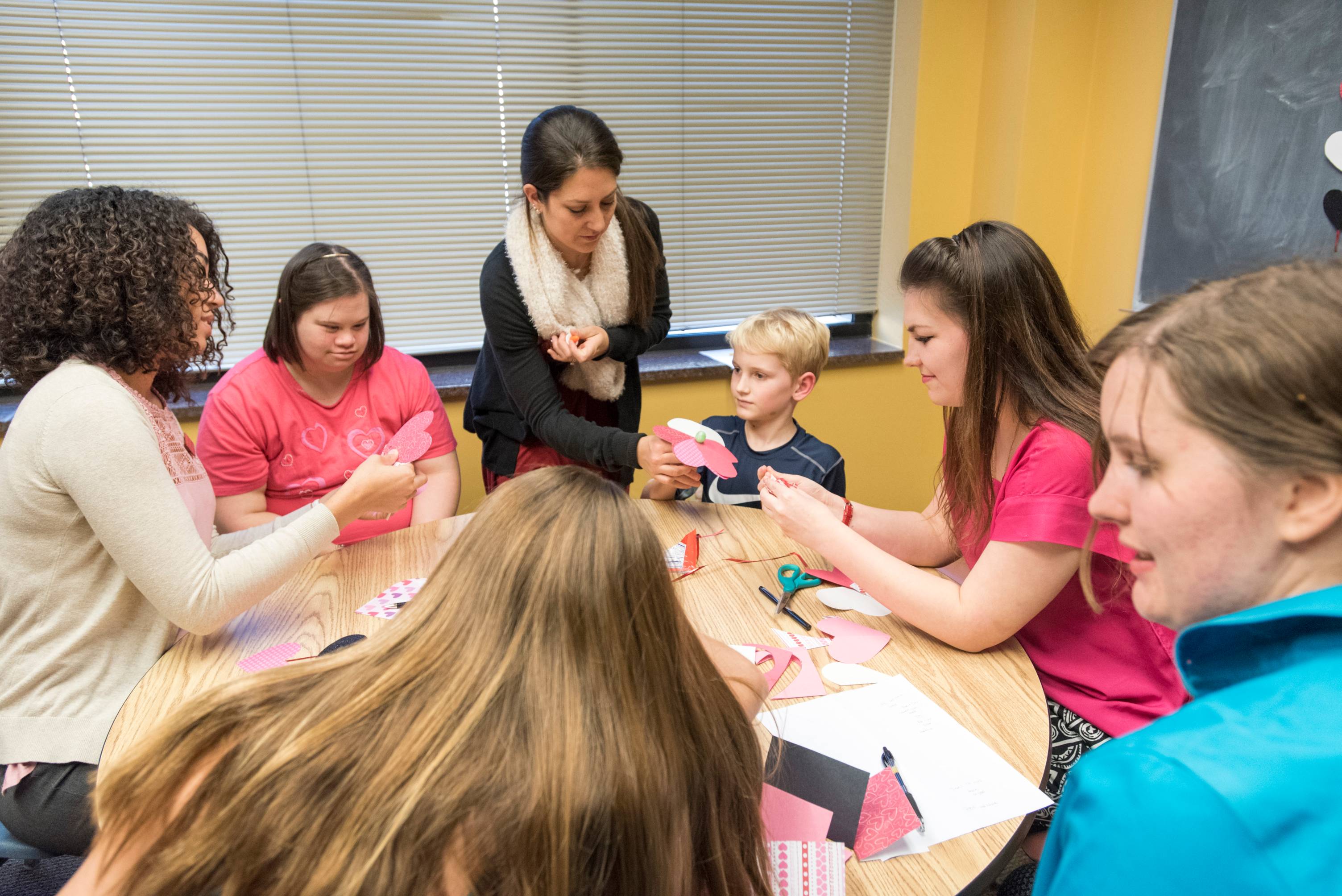 Student clinicians working with patients in a craft activity.