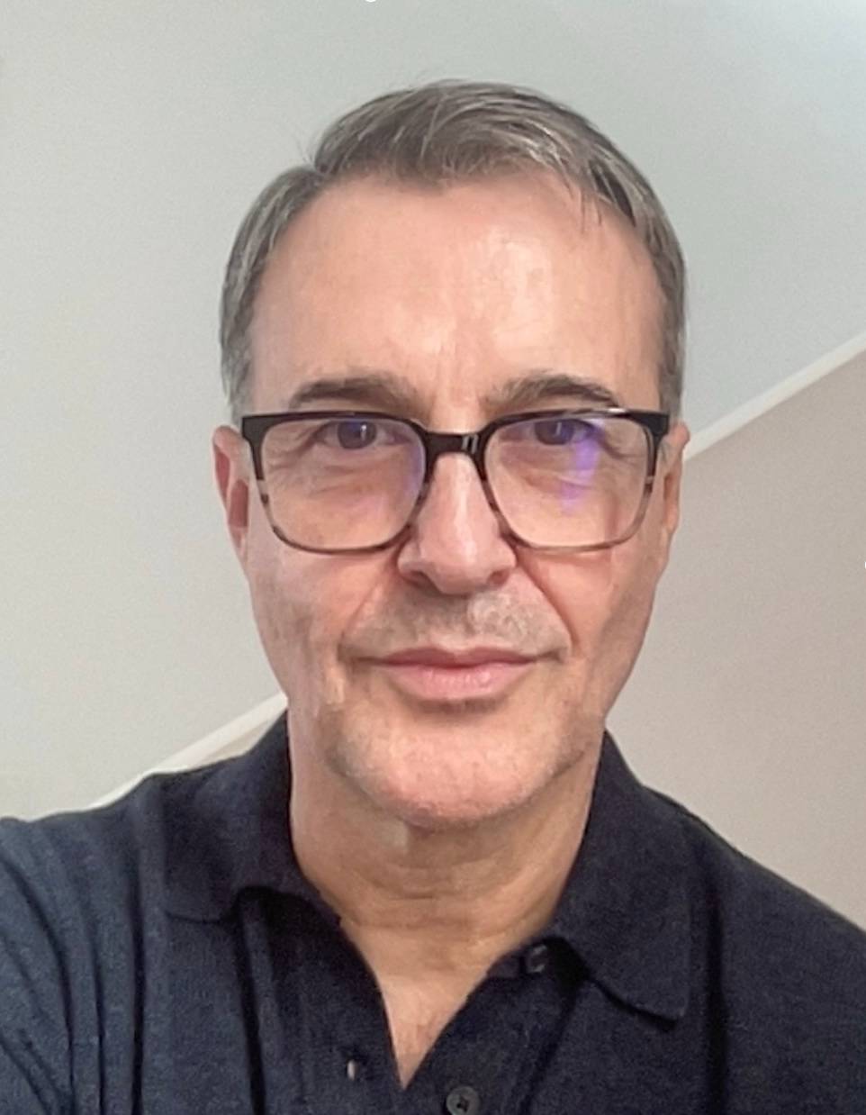 head shot of man with glasses, dark shirt