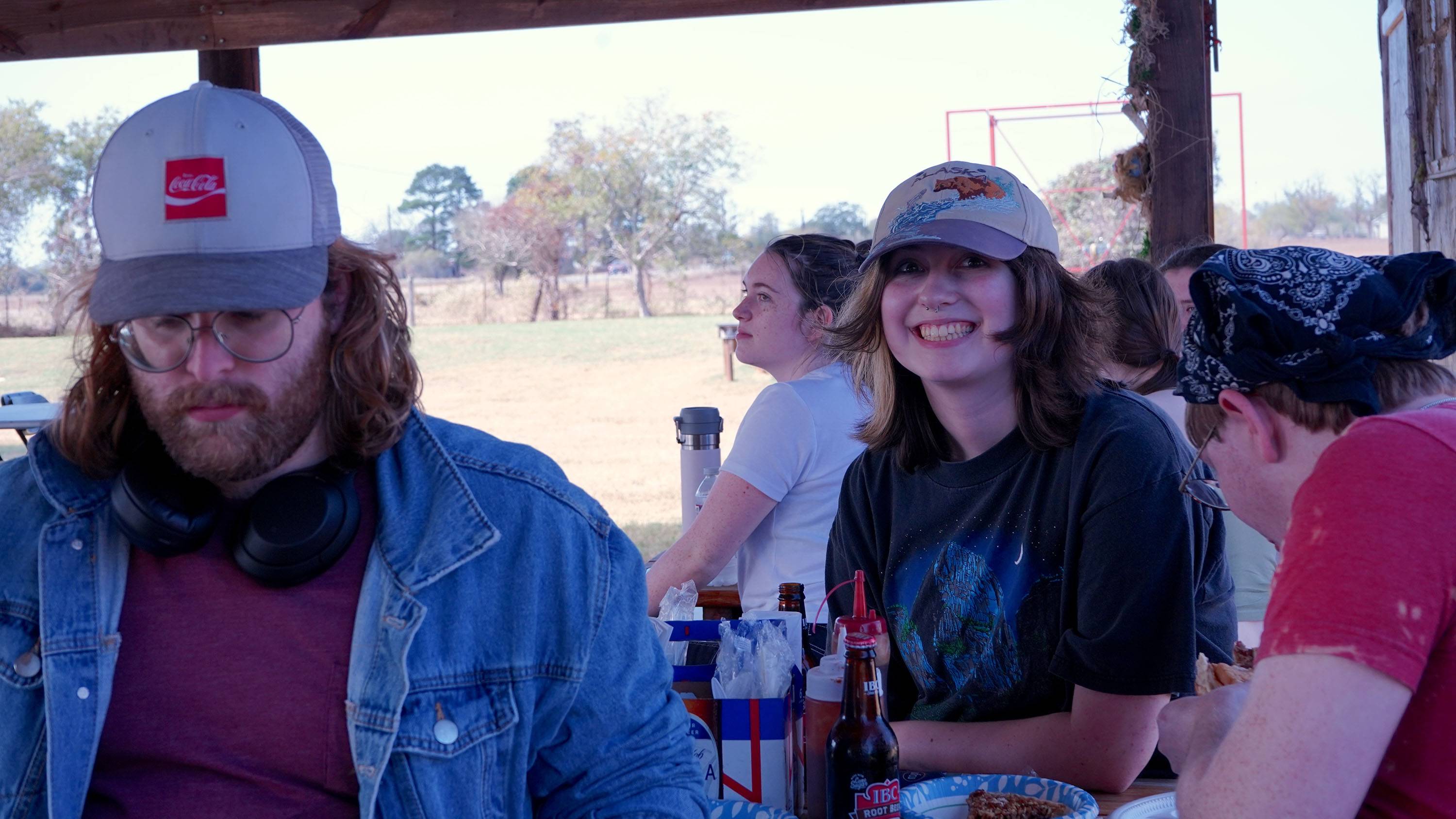 A student smiles for the camera while eating lunch with other students at The Gas Station.