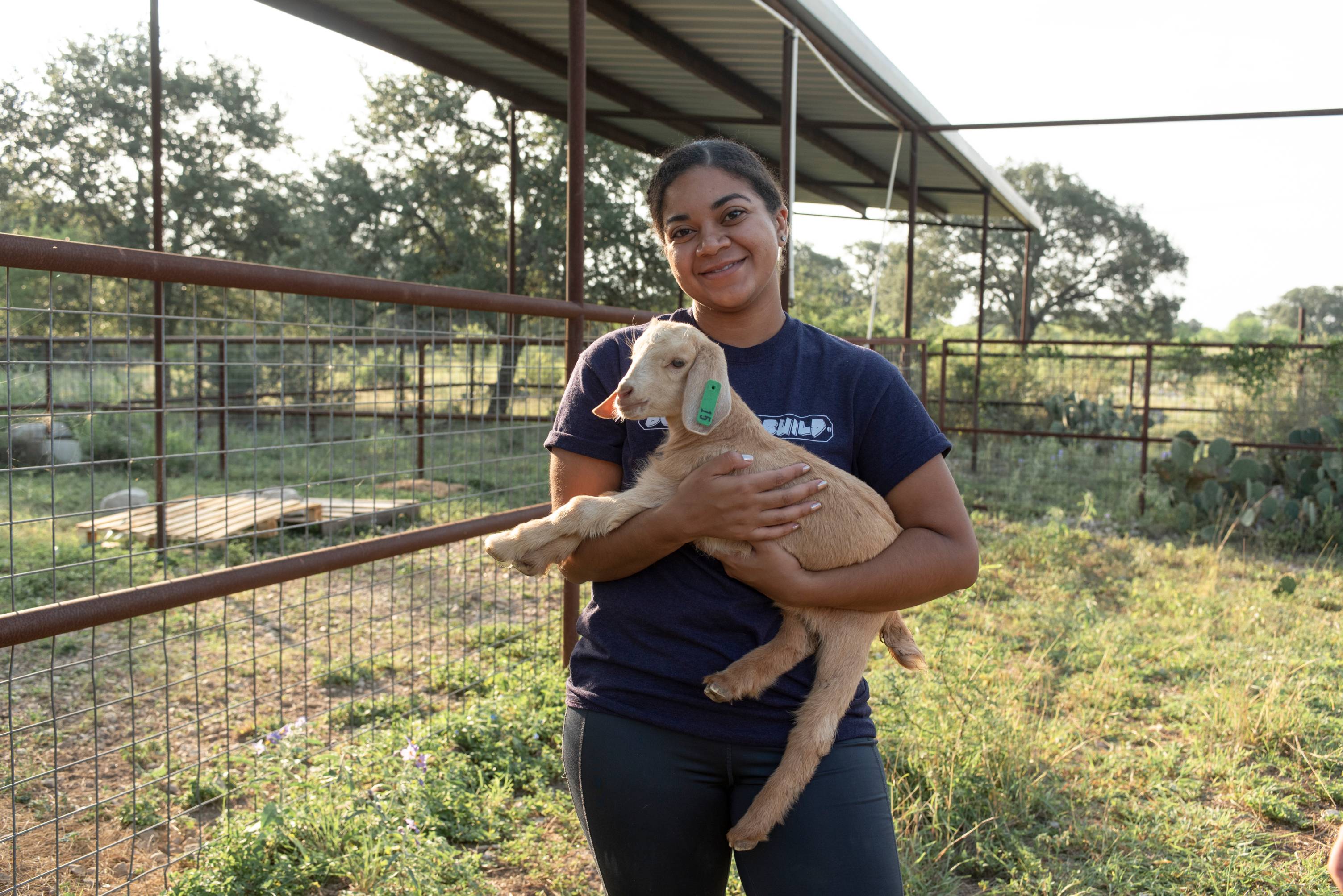 Young woman holding a goat.