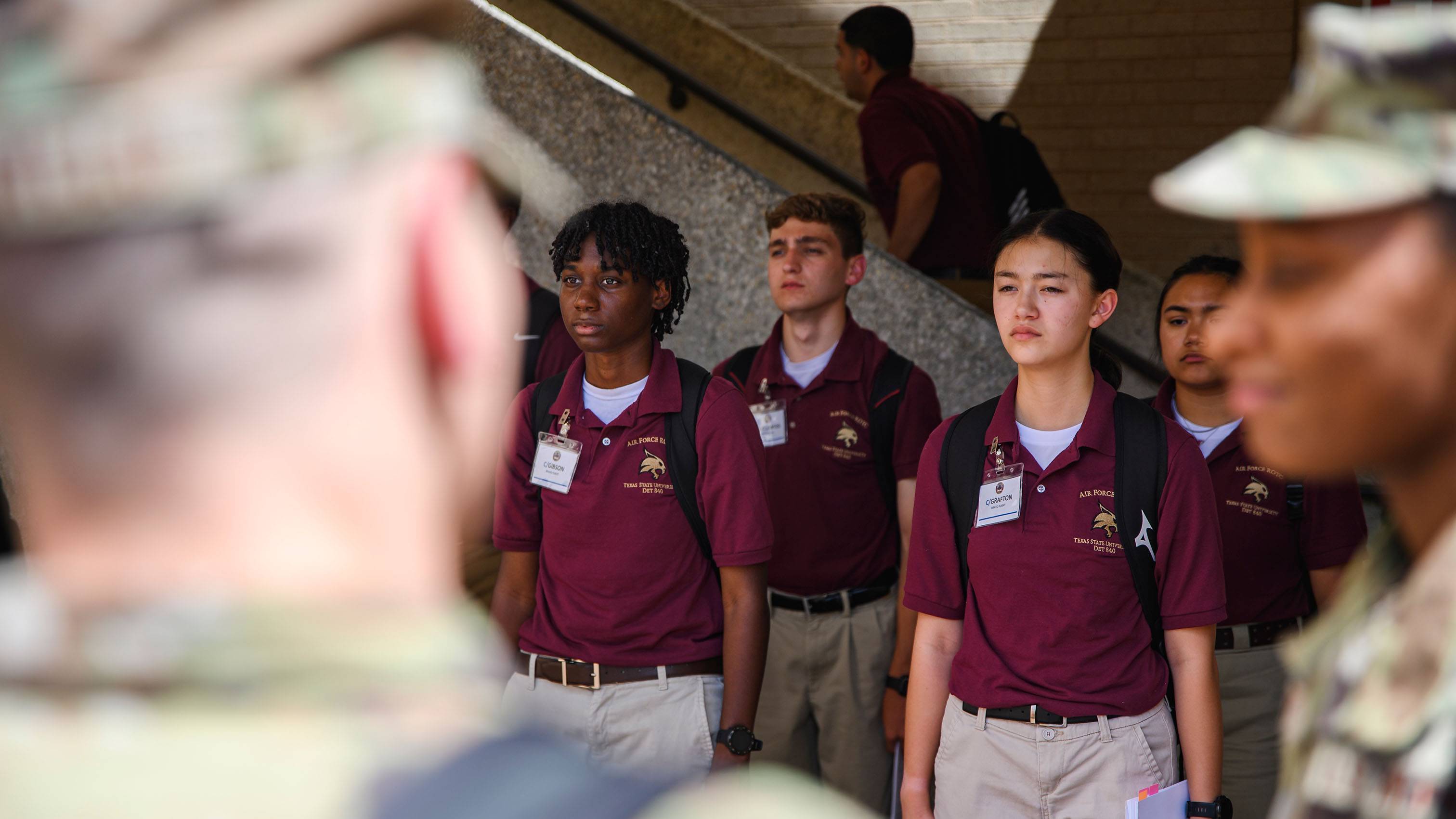 A group of TXST Air Force students stand in line talking to veterans.