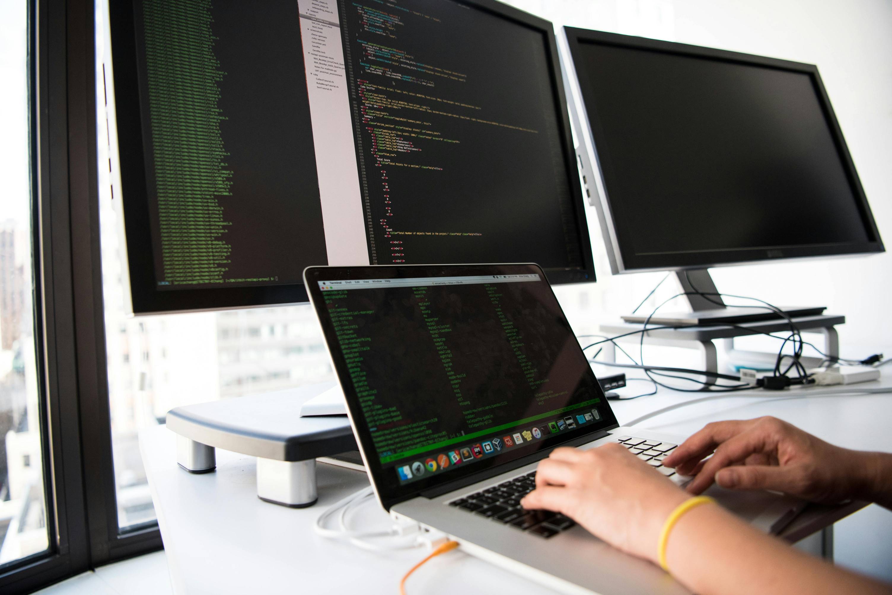 A young lady on the computer with multiple screens