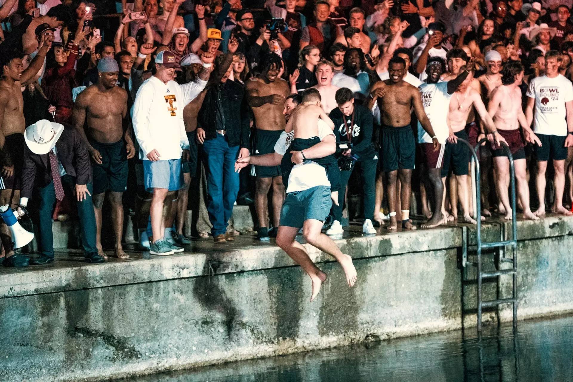 a group of people jumping into a river